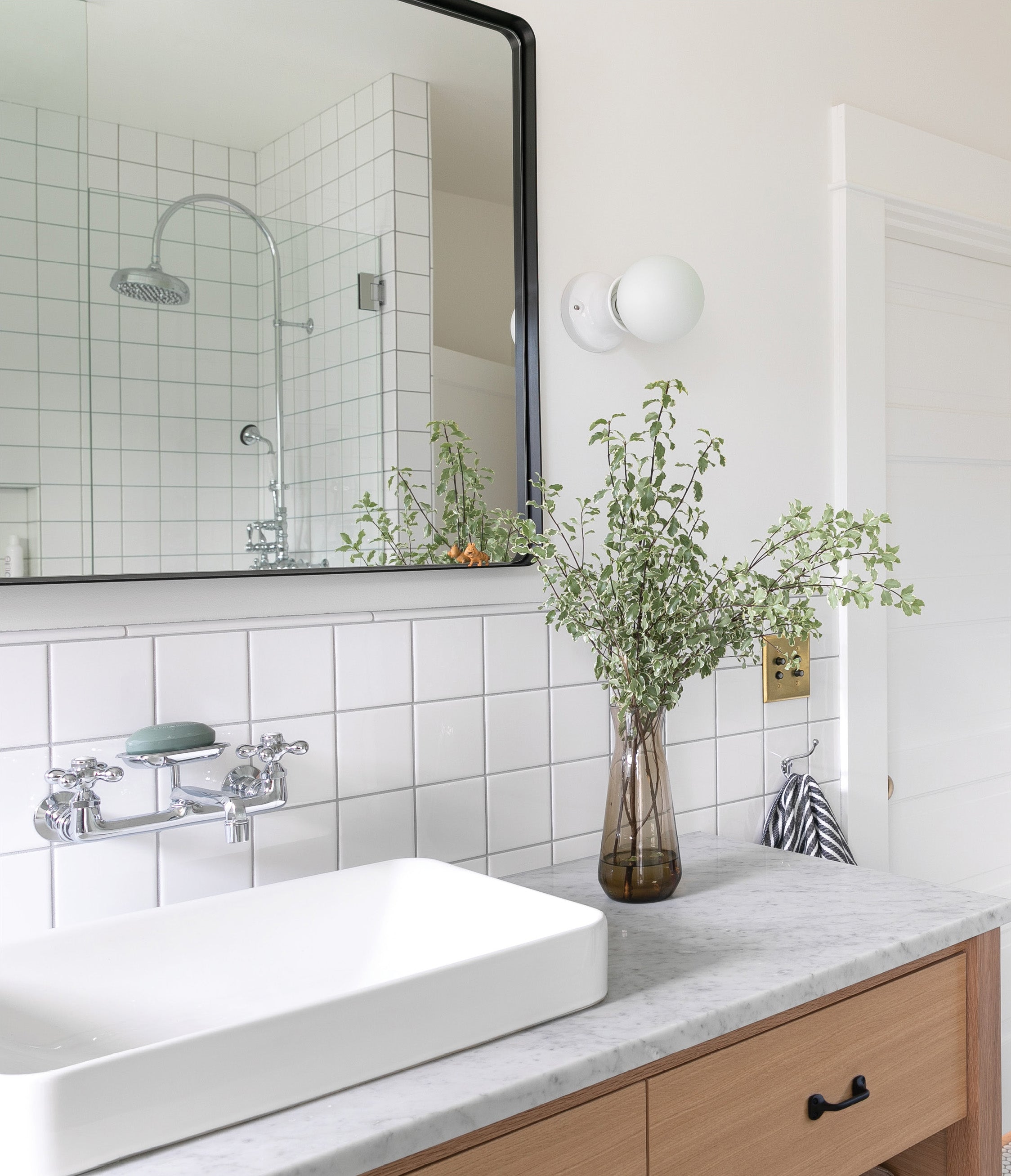 vase of flowers sits on a countertop in a bathroom