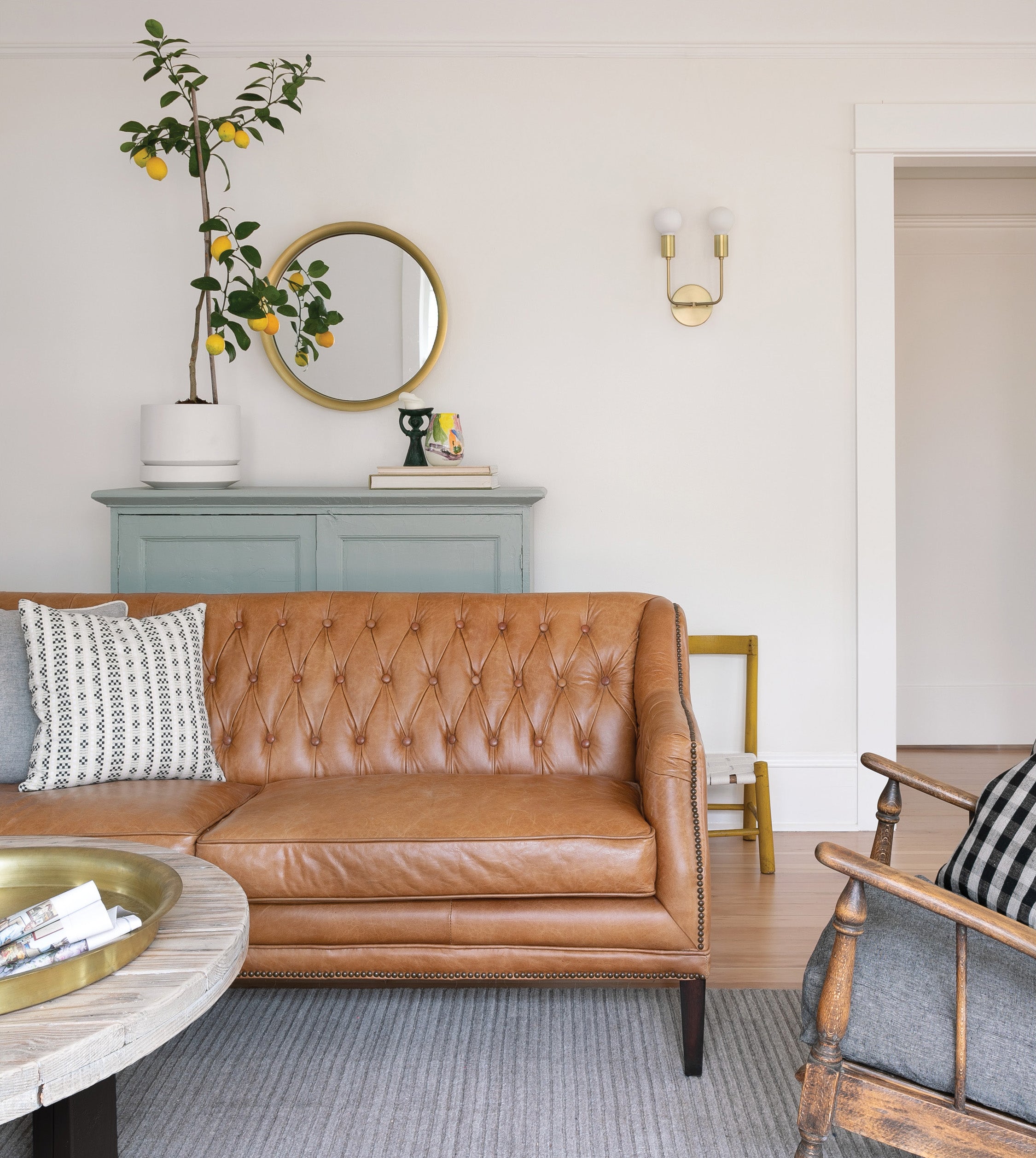 living room with a brown couch and a mirror