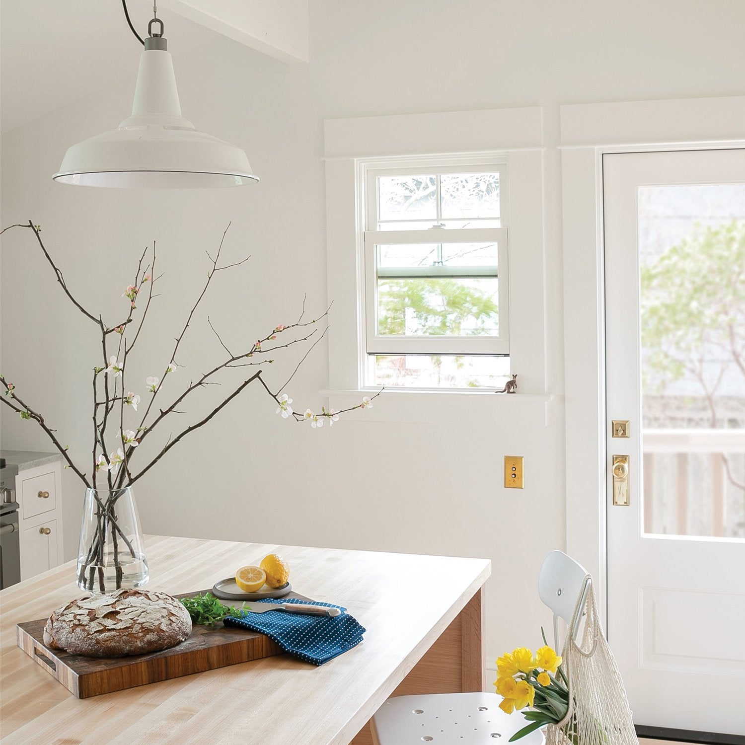 white room with a table and a ceiling light fixture