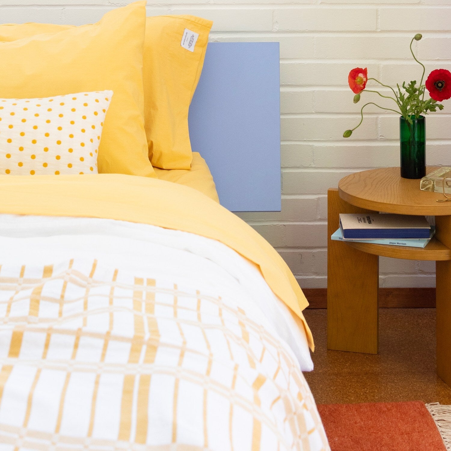 Layered yellow bedding on a blue bed.