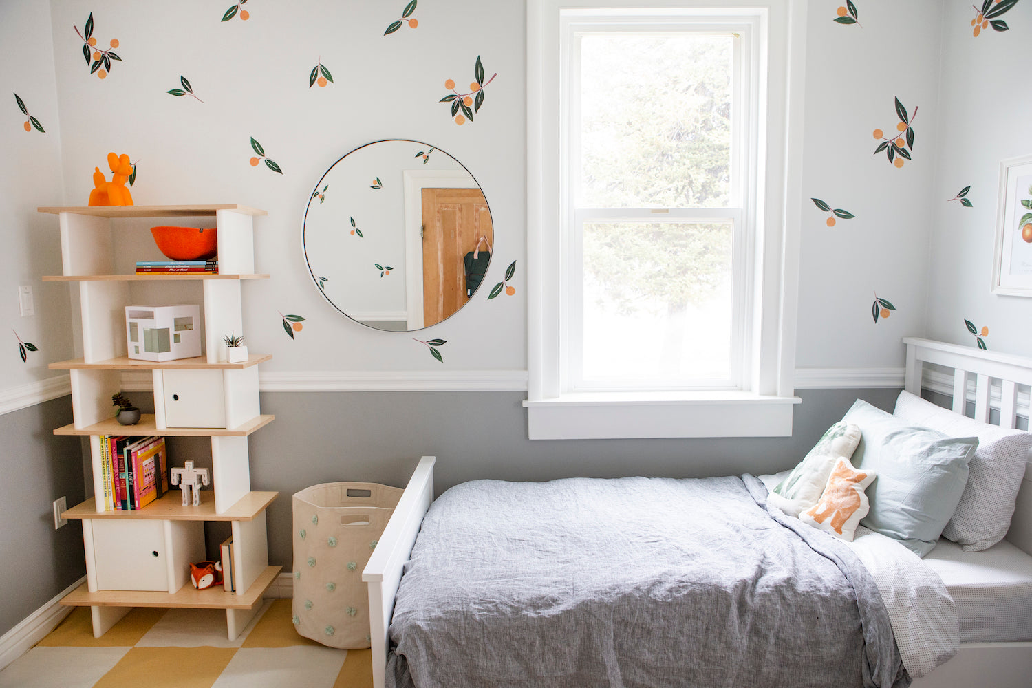 bedroom with a gray bed and a mirror and shelves