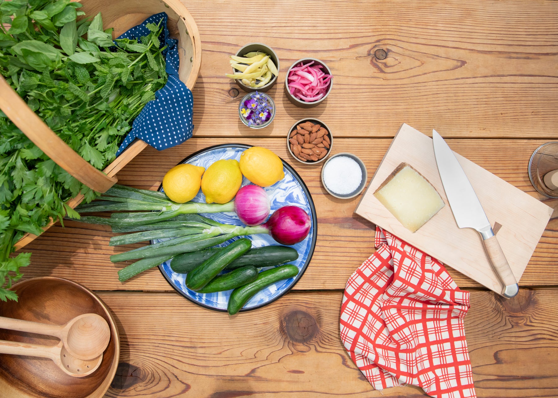 table with vegetables and a cutting board