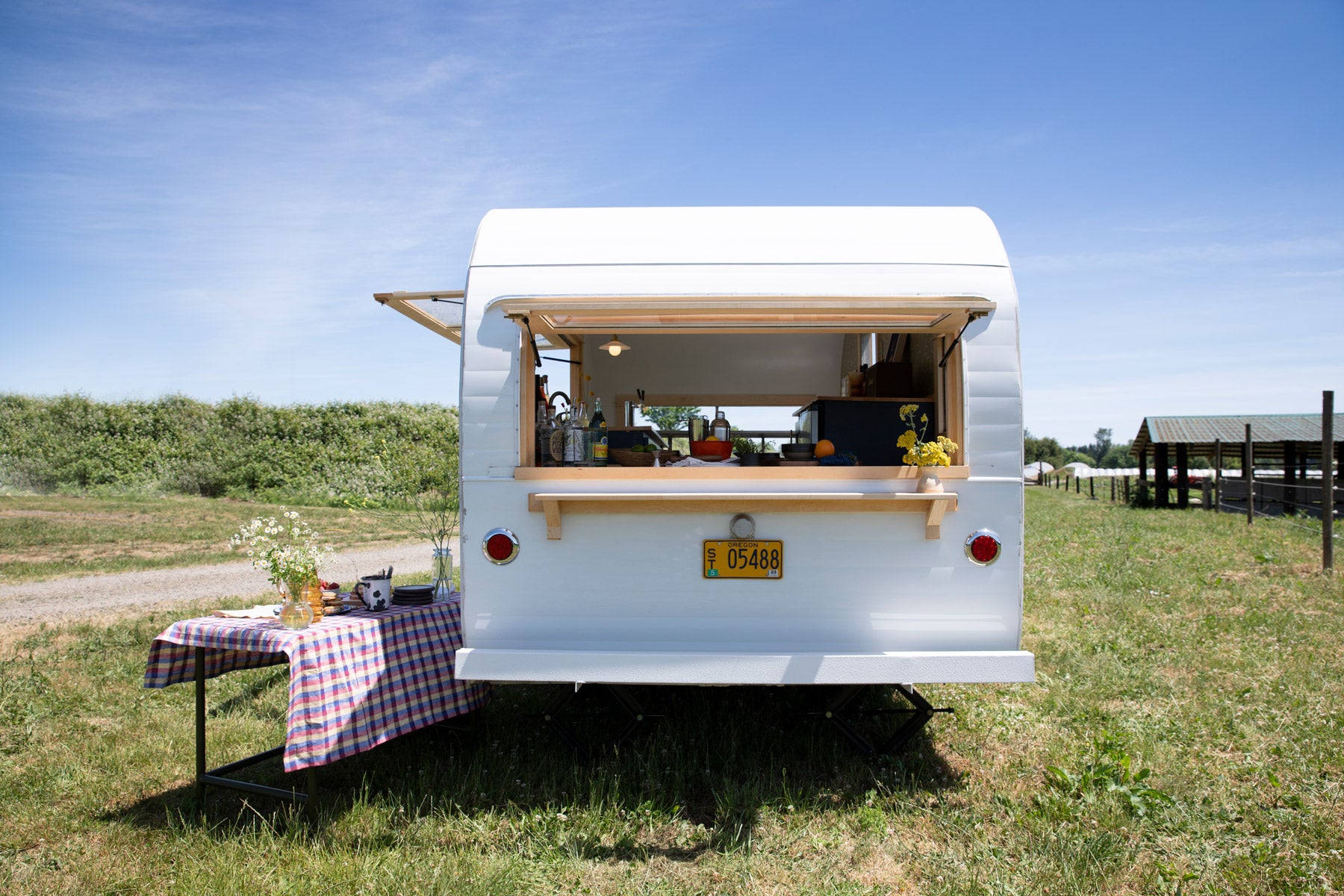 small white trailer with a table and a picnic table