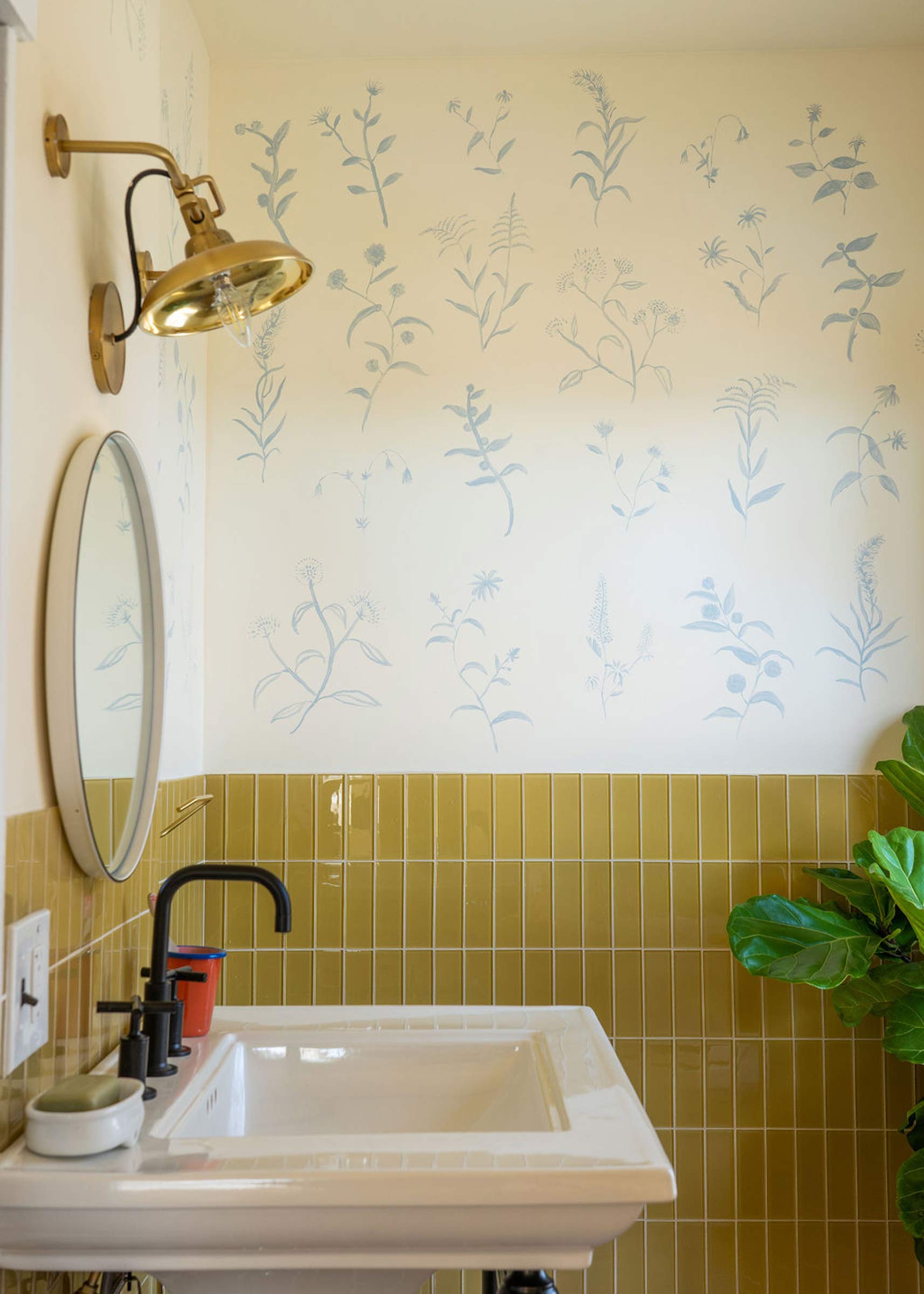 The Grant Mirror in a tiled bathroom with hand-painted walls. 