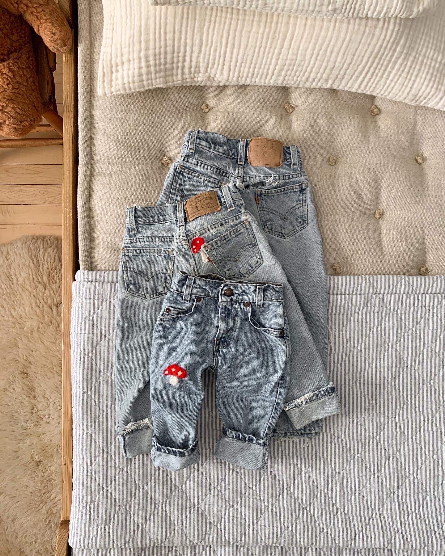 aerial view of blue denim jeans laid out on a bed