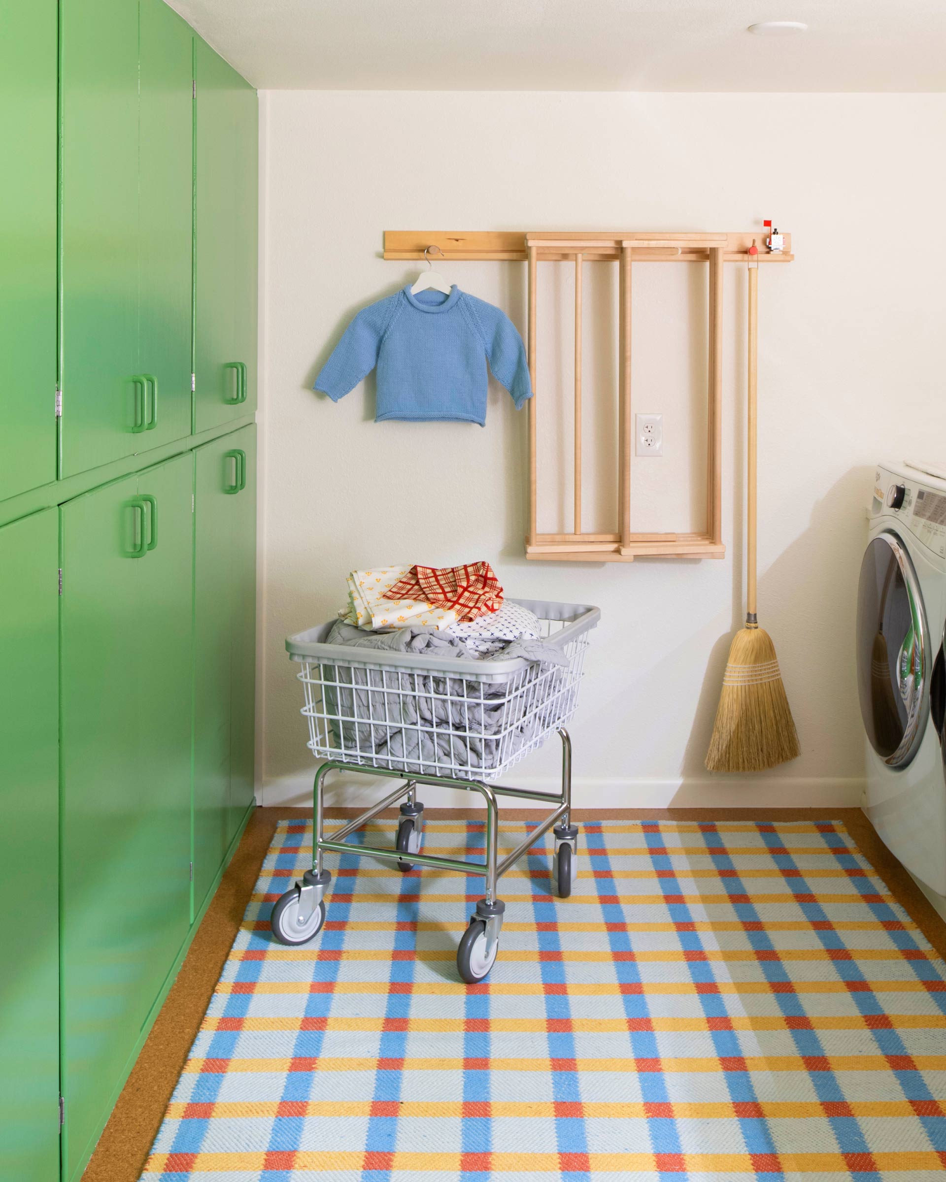 Laundry room with bright green cabinet.