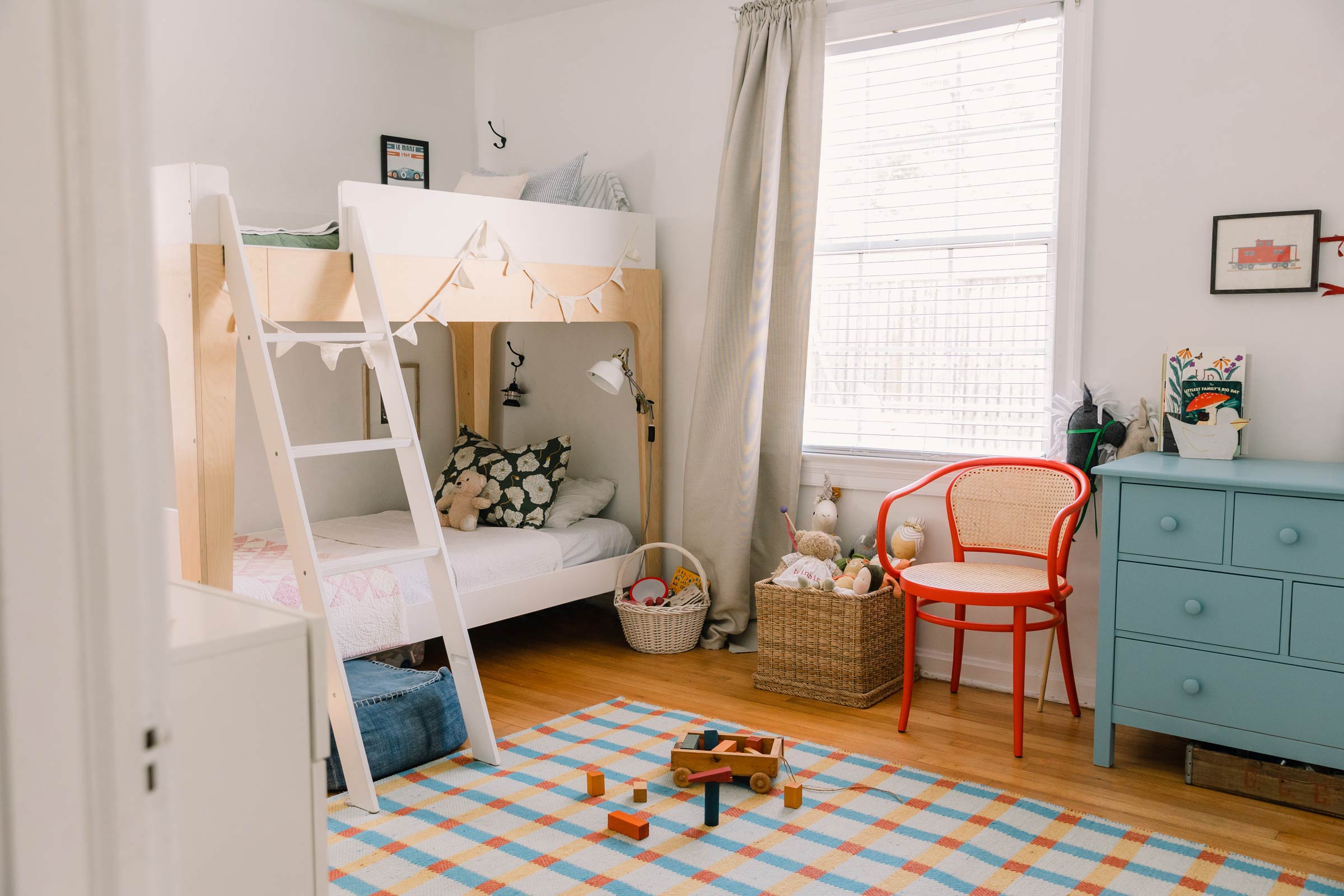 A kid's room with a plaid wool rug and bunk beds. 