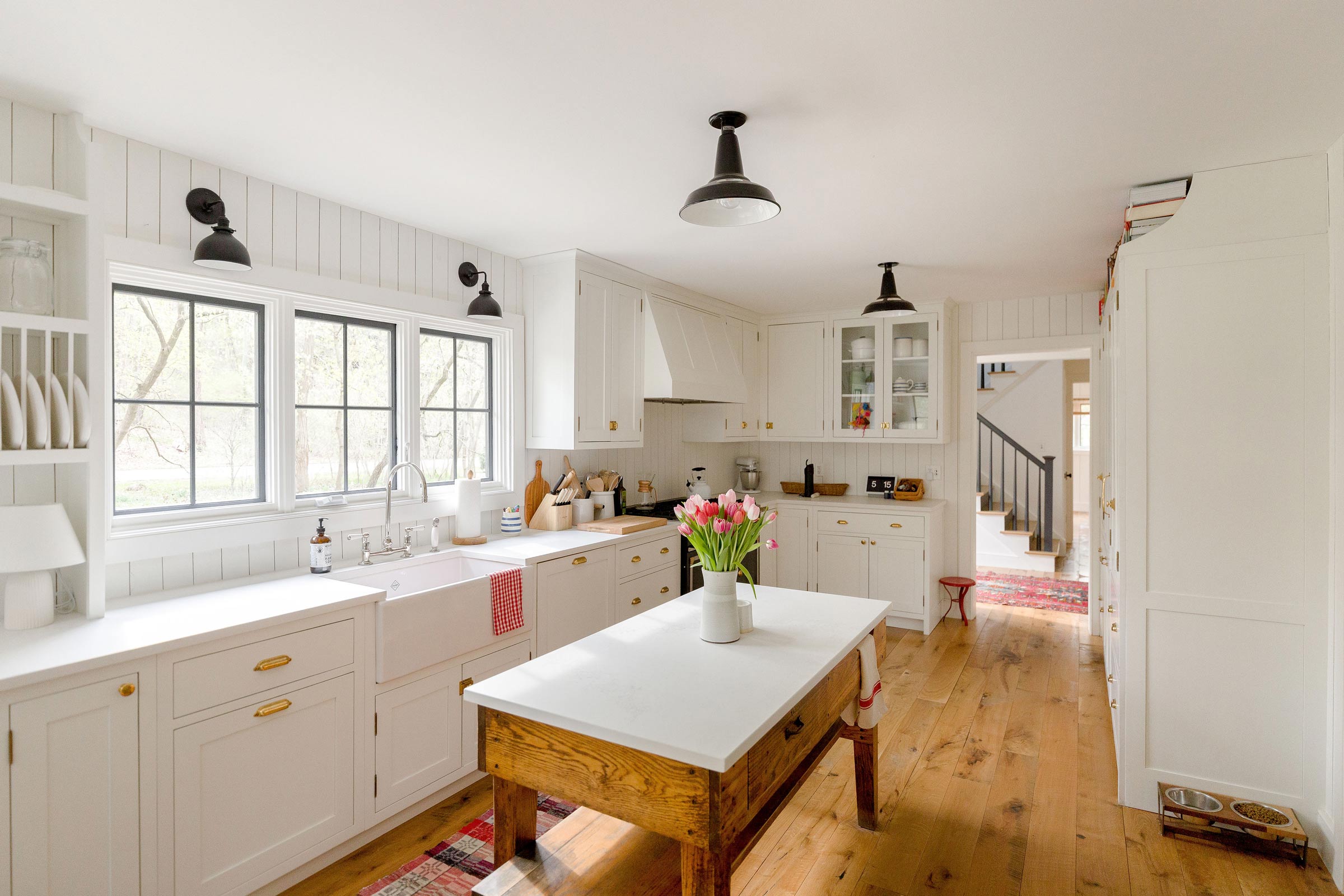 A modern open kitchen with factory-style light fixtures. 