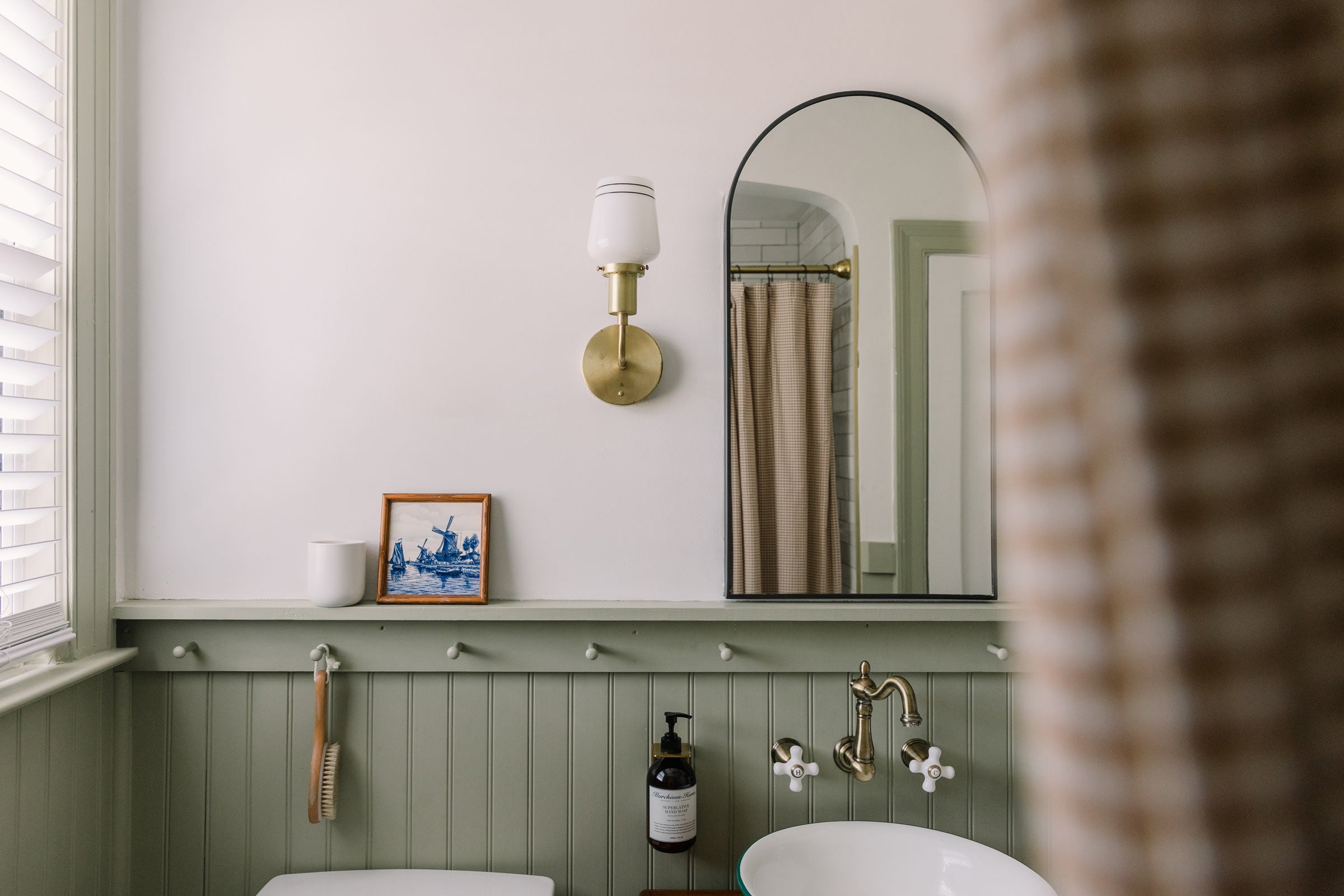 A vintage-inspired bathroom with brass wall sconces. 