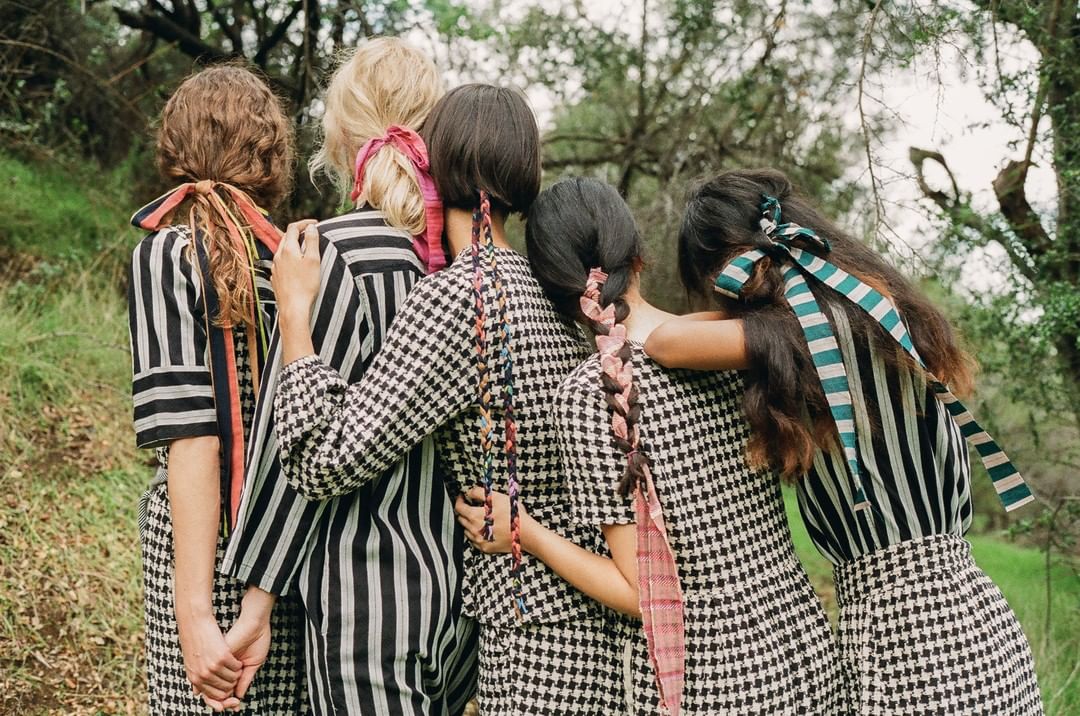 group of people in a forest wearing black and white gingham print outfits