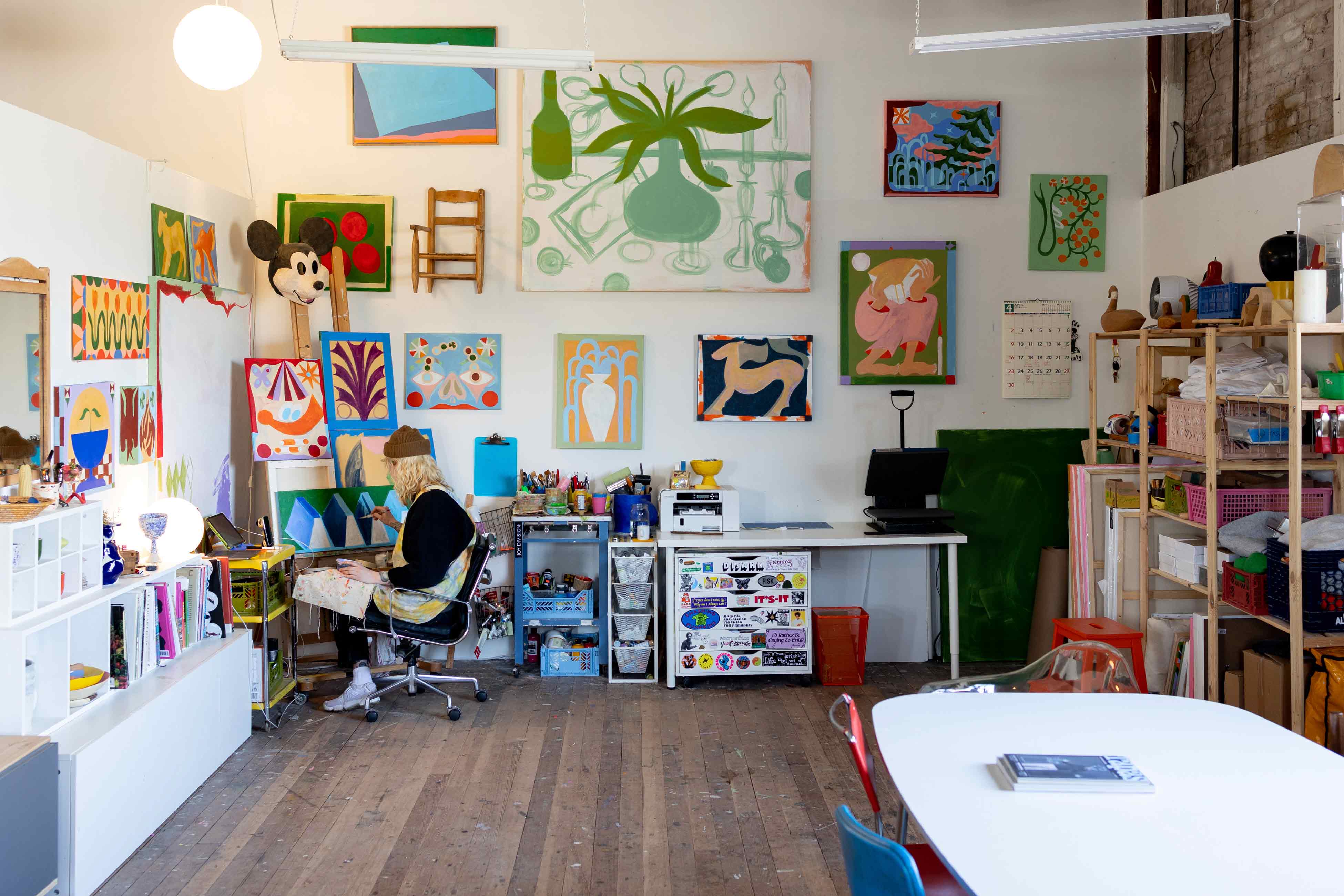 Artist working on a painting in colorful and vibrant art studio. 