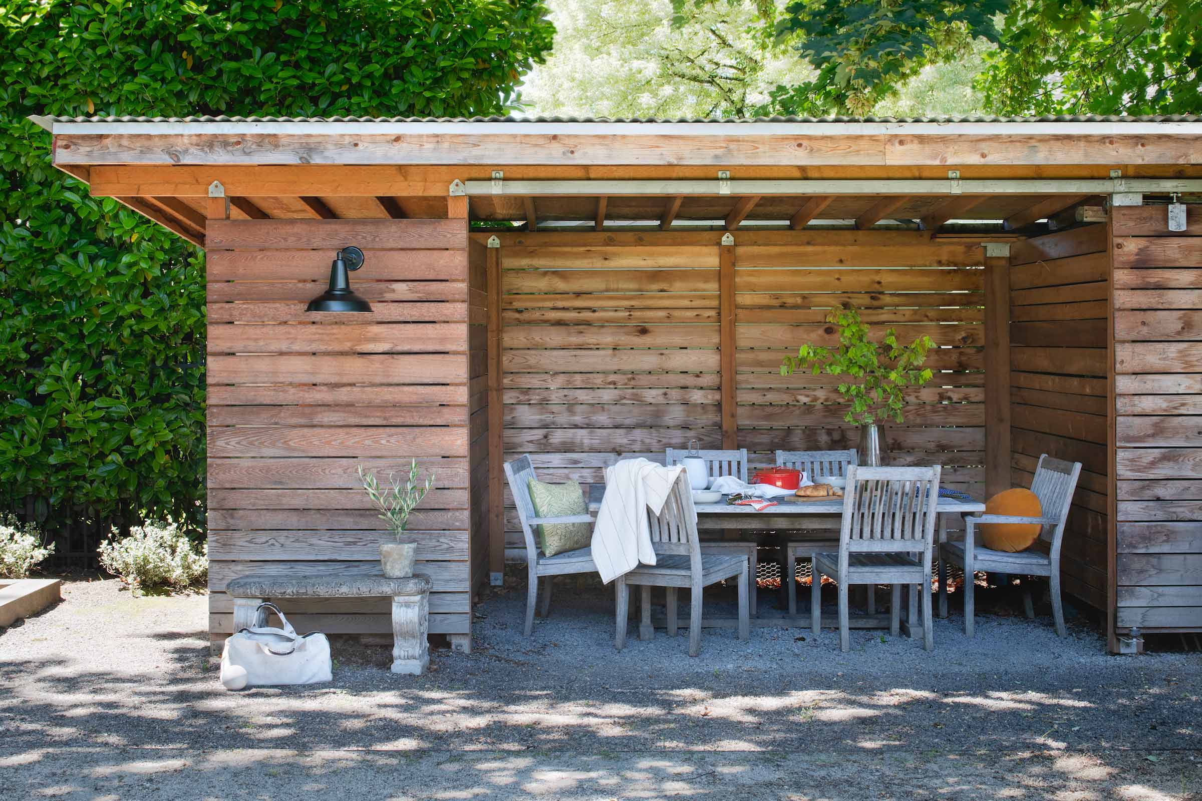 Backyard with wall sconce and covered sitting area. 