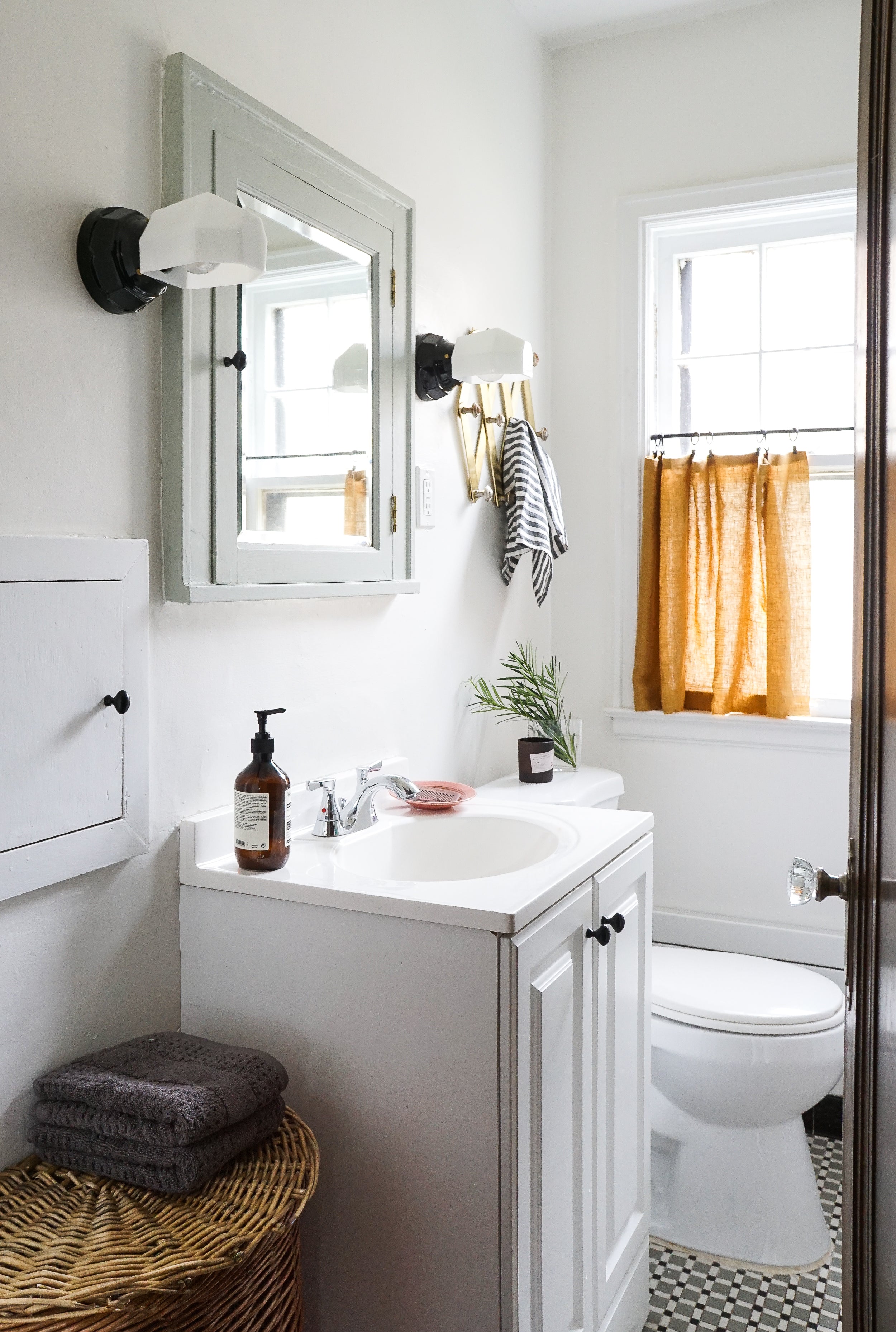 bathroom with a sink toilet and a mirror and sconces