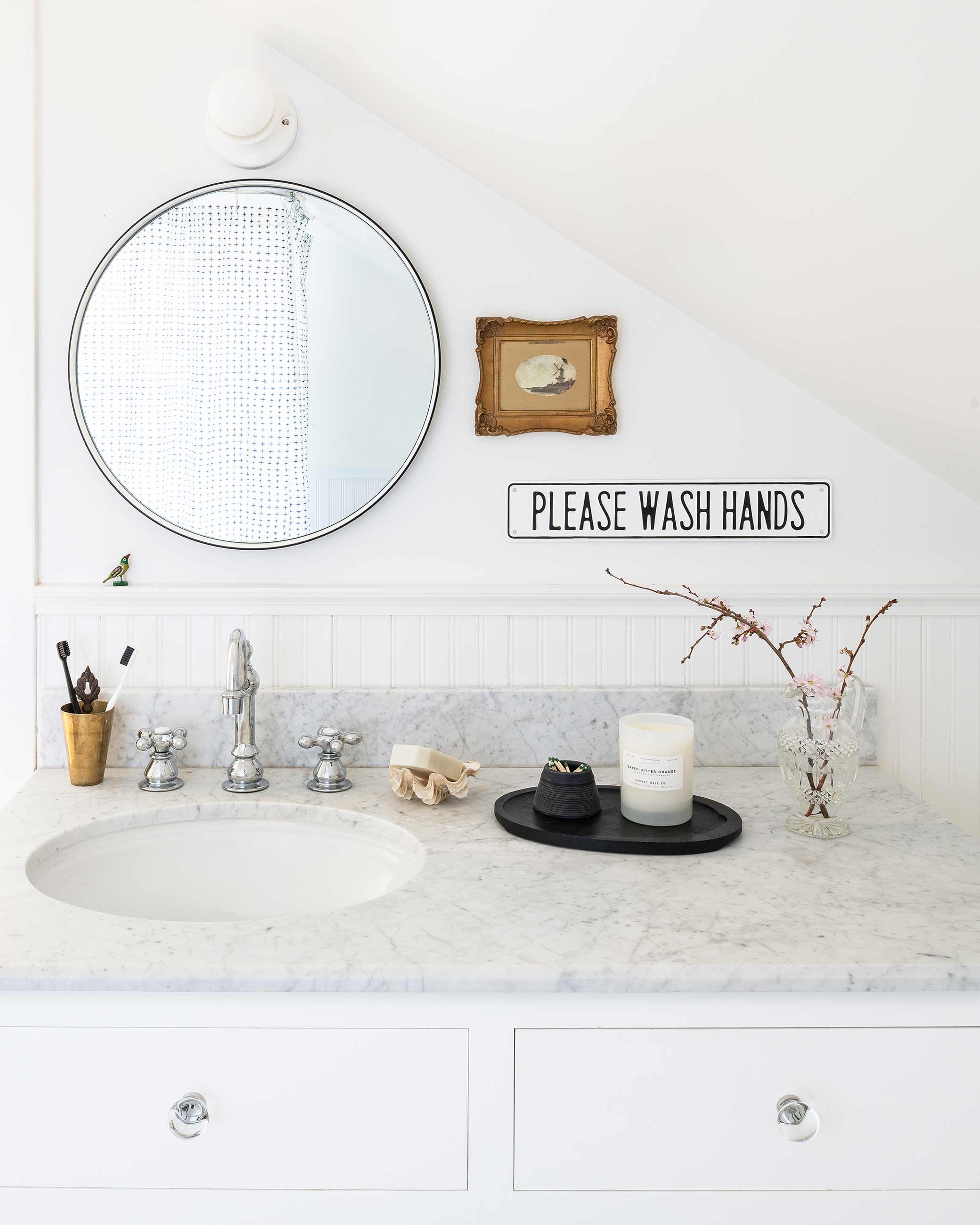 Bathroom mirror over granite countertop and white sink.