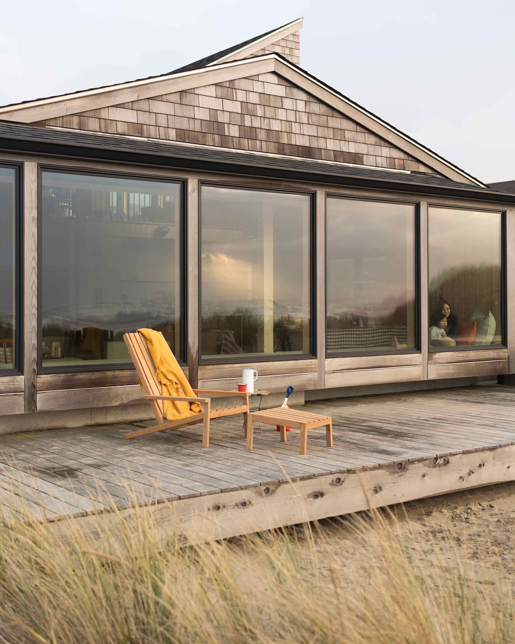 Beach house with lounge chair on deck.