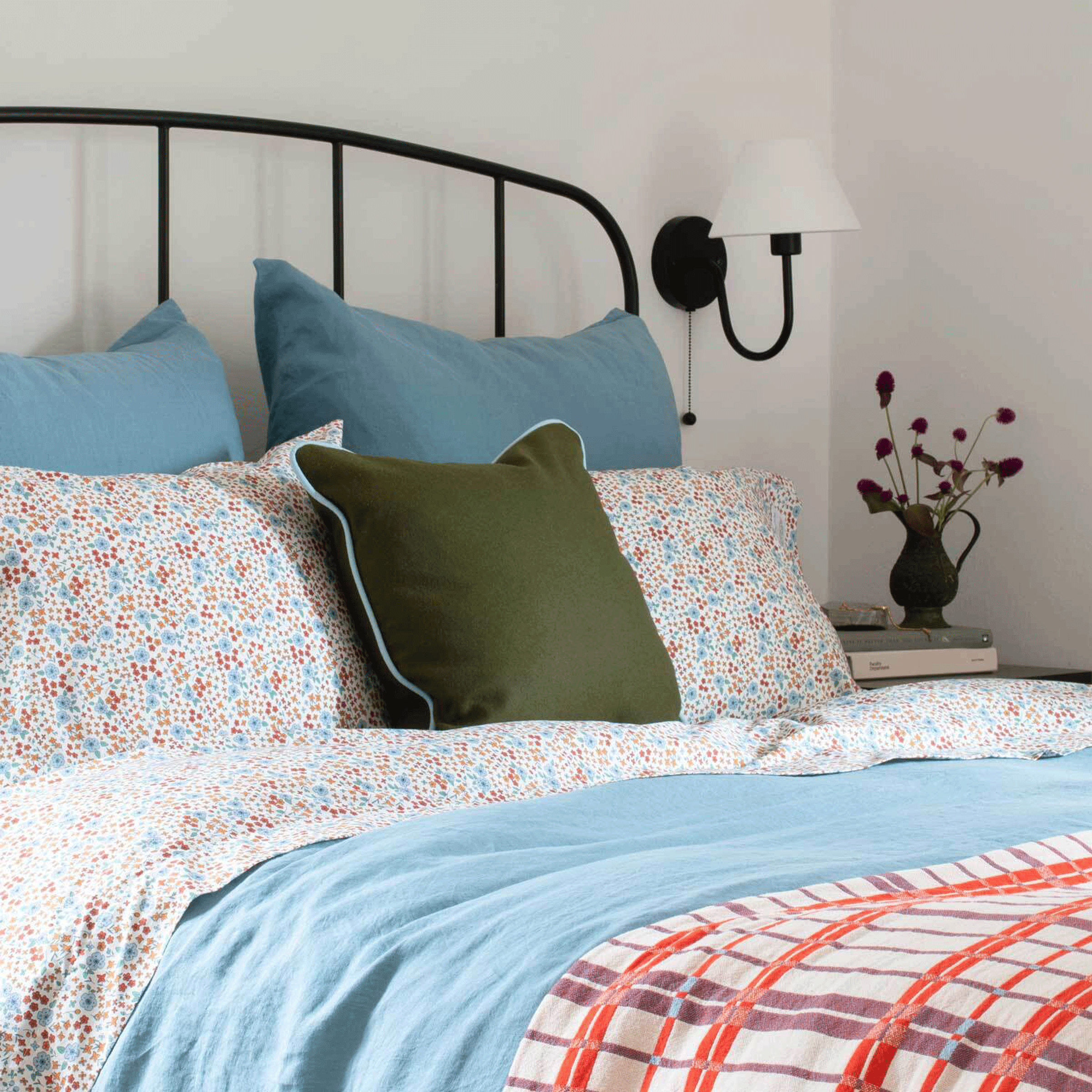 a bed made with a light blue linen