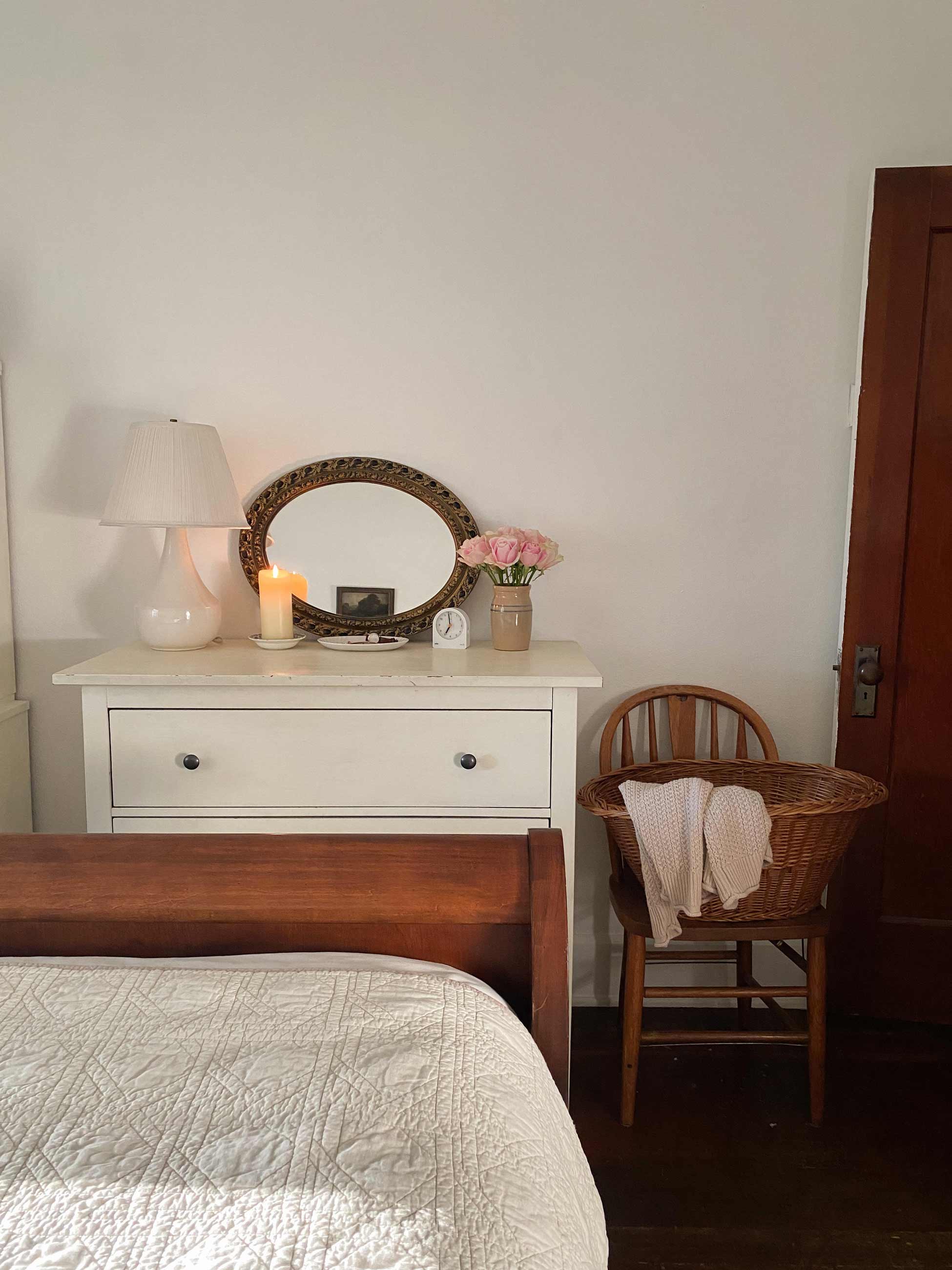 Cozy bedroom with alarm clock on top of dresser.