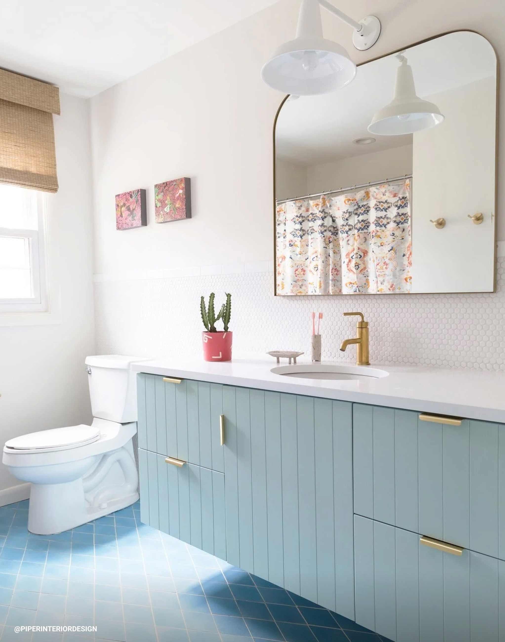 Blue bathroom vanity with white countertop and sink. 