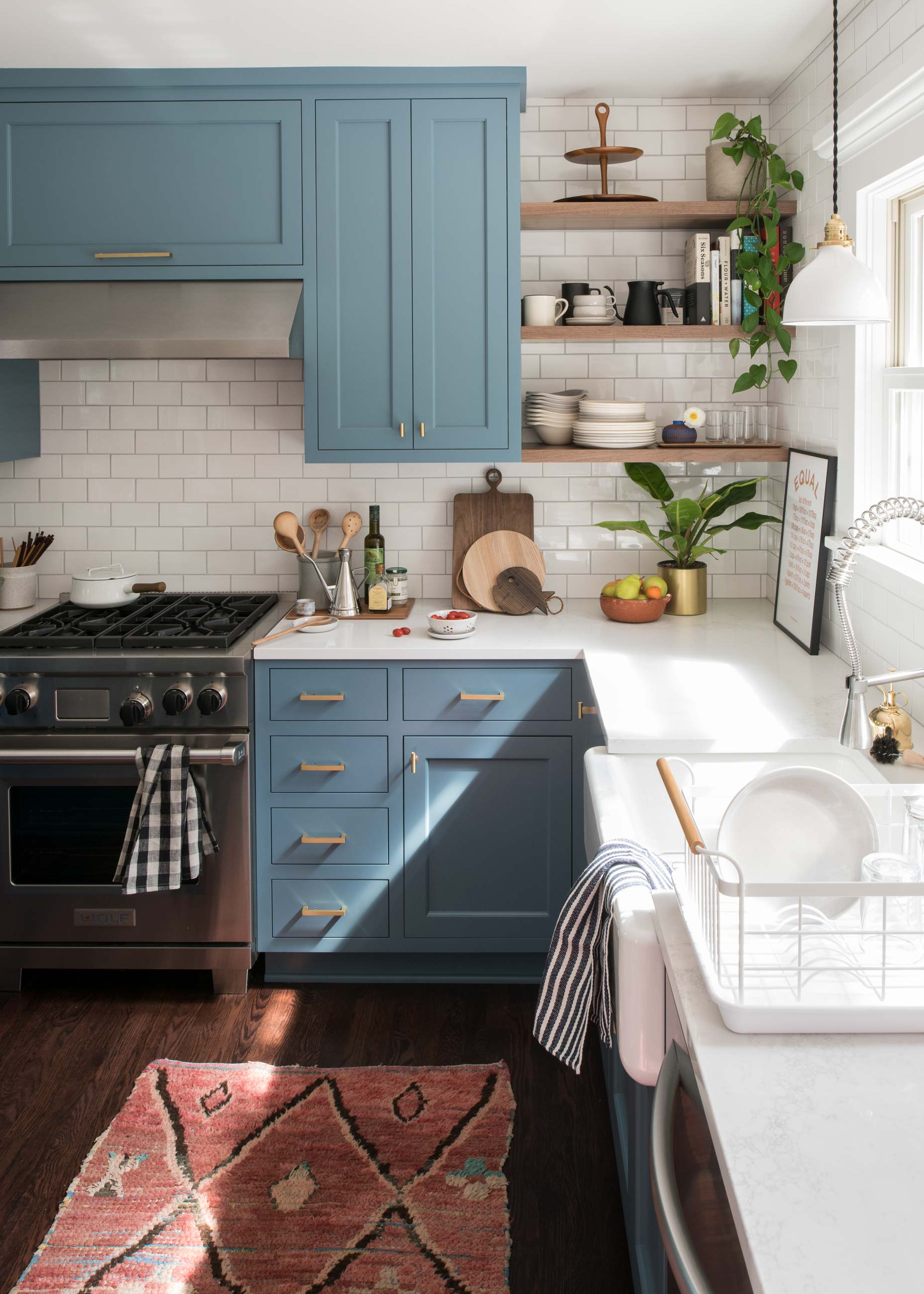 Light and bright kitchen with blue cabinets. 