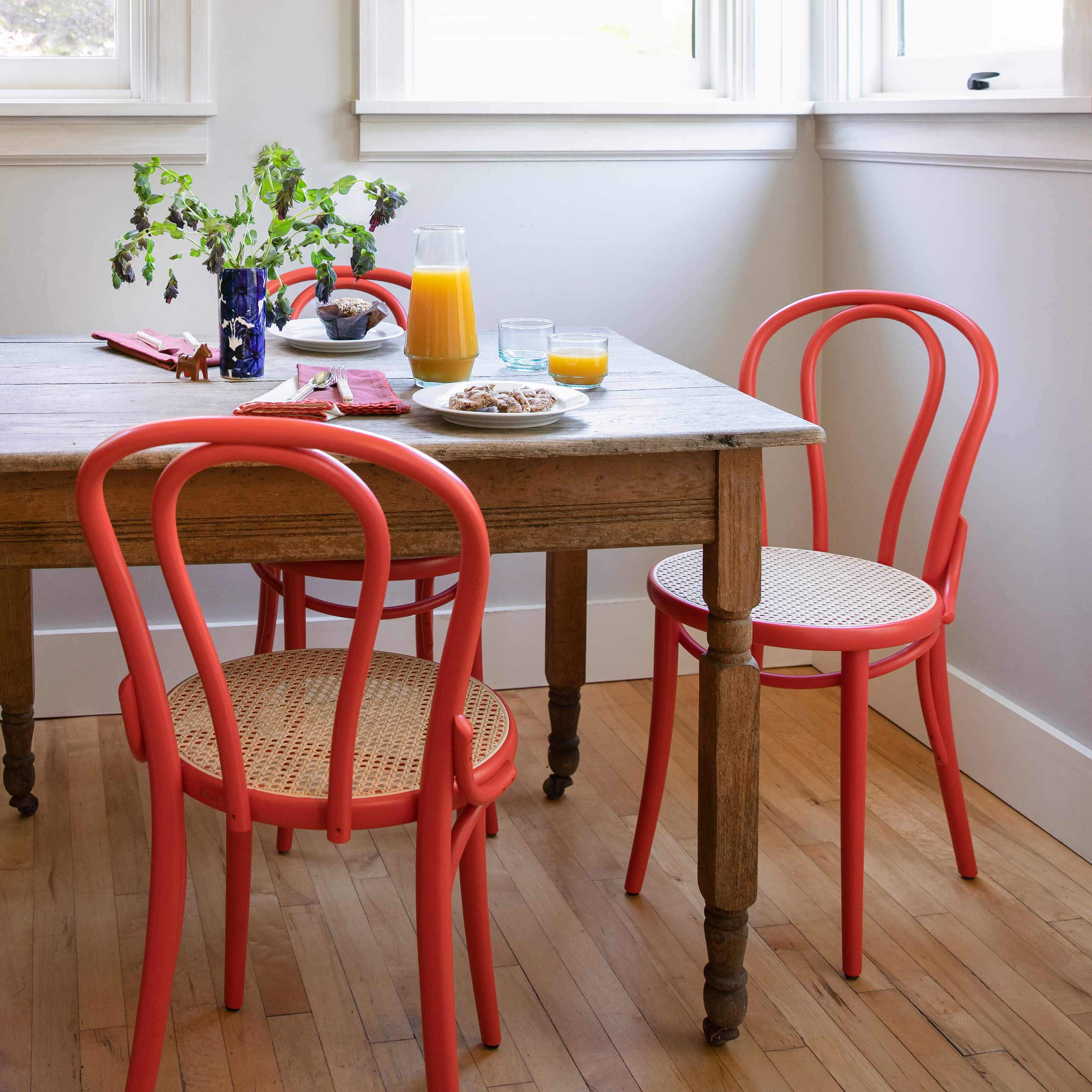 Breakfast nook with red bentwood cane chairs. 