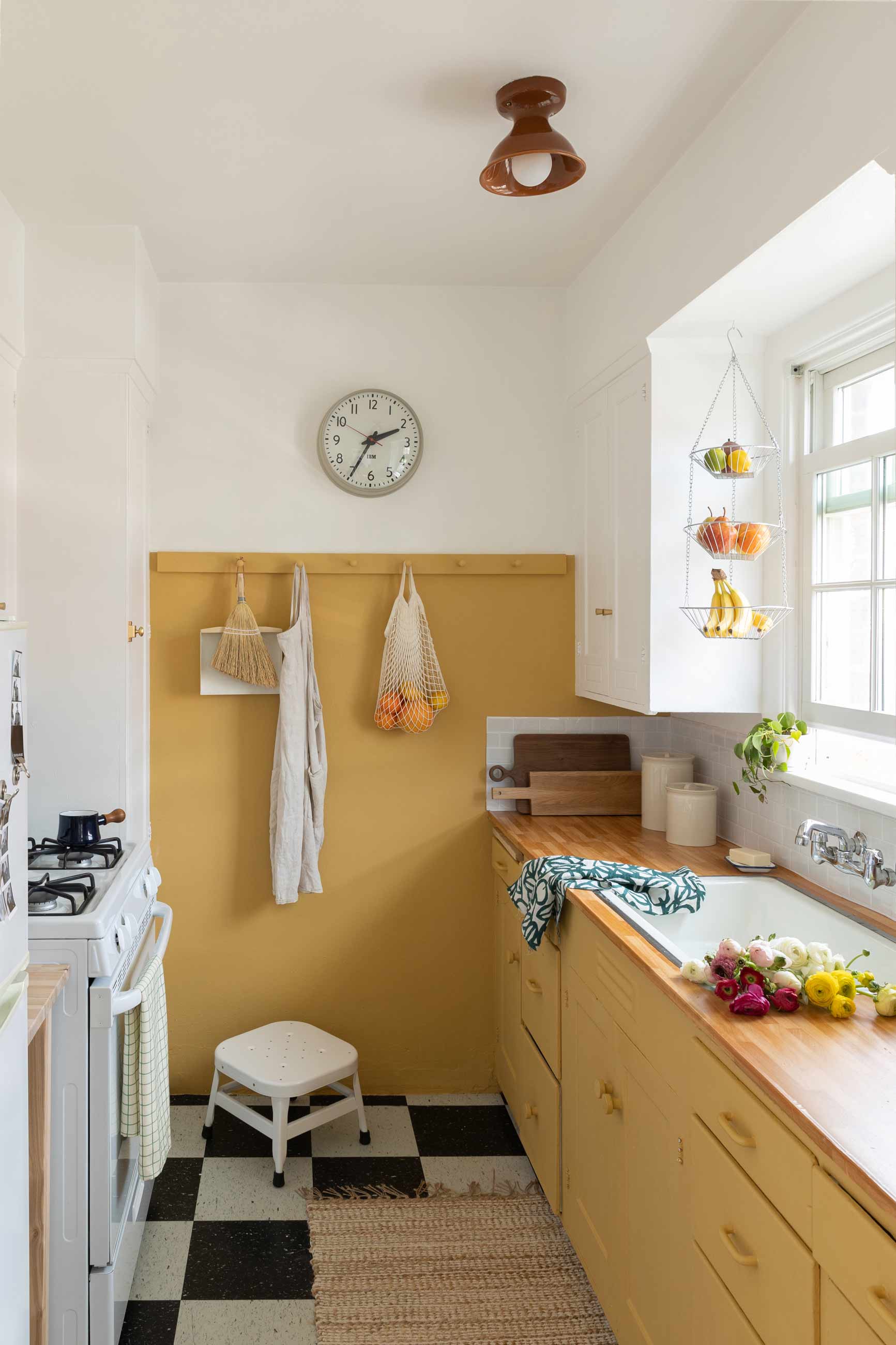 Bright and sunny kitchen with yellow and white cabinets and butcher-block countertops. 