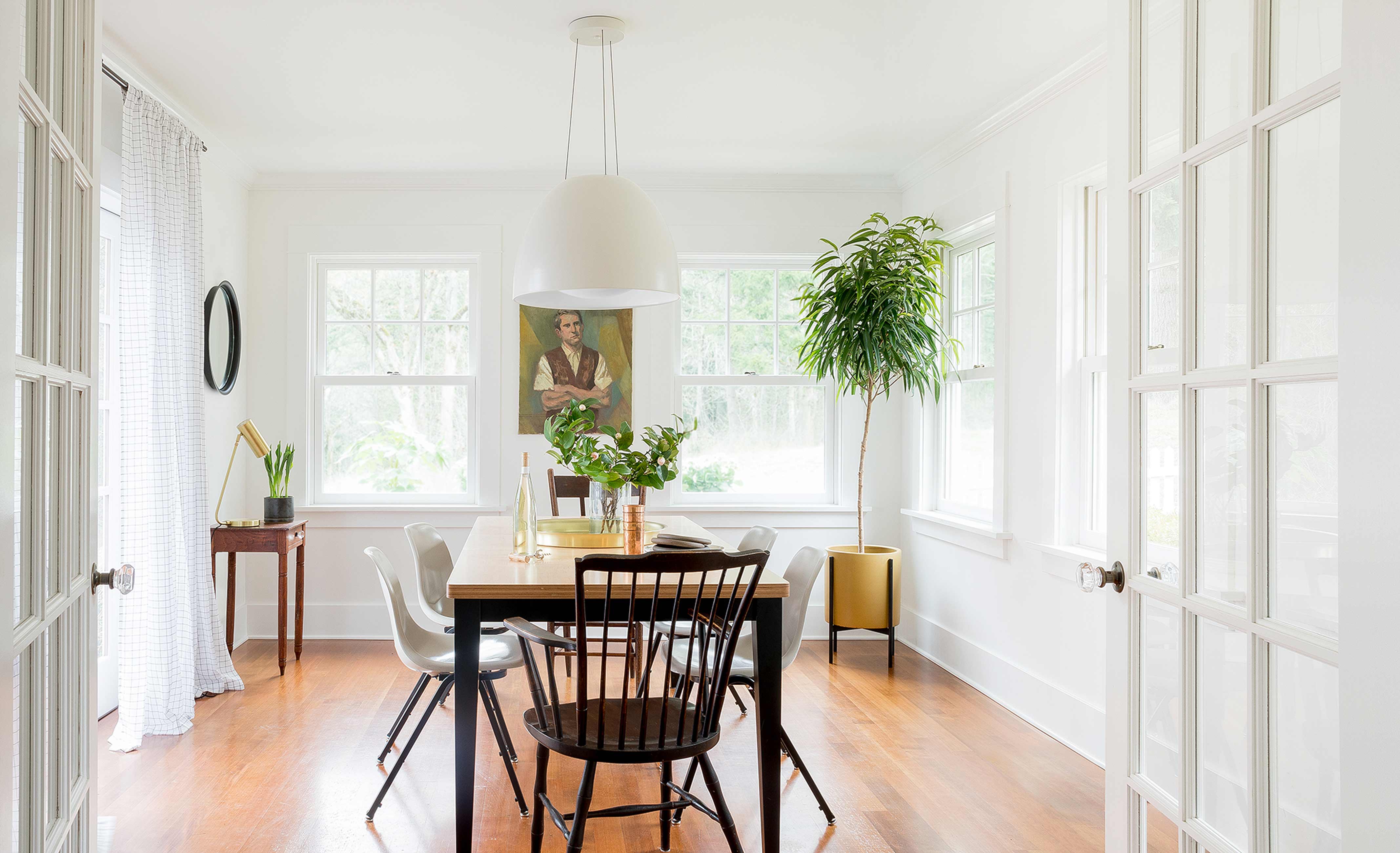 Sunny and bright dining room with black chairs and wood table.