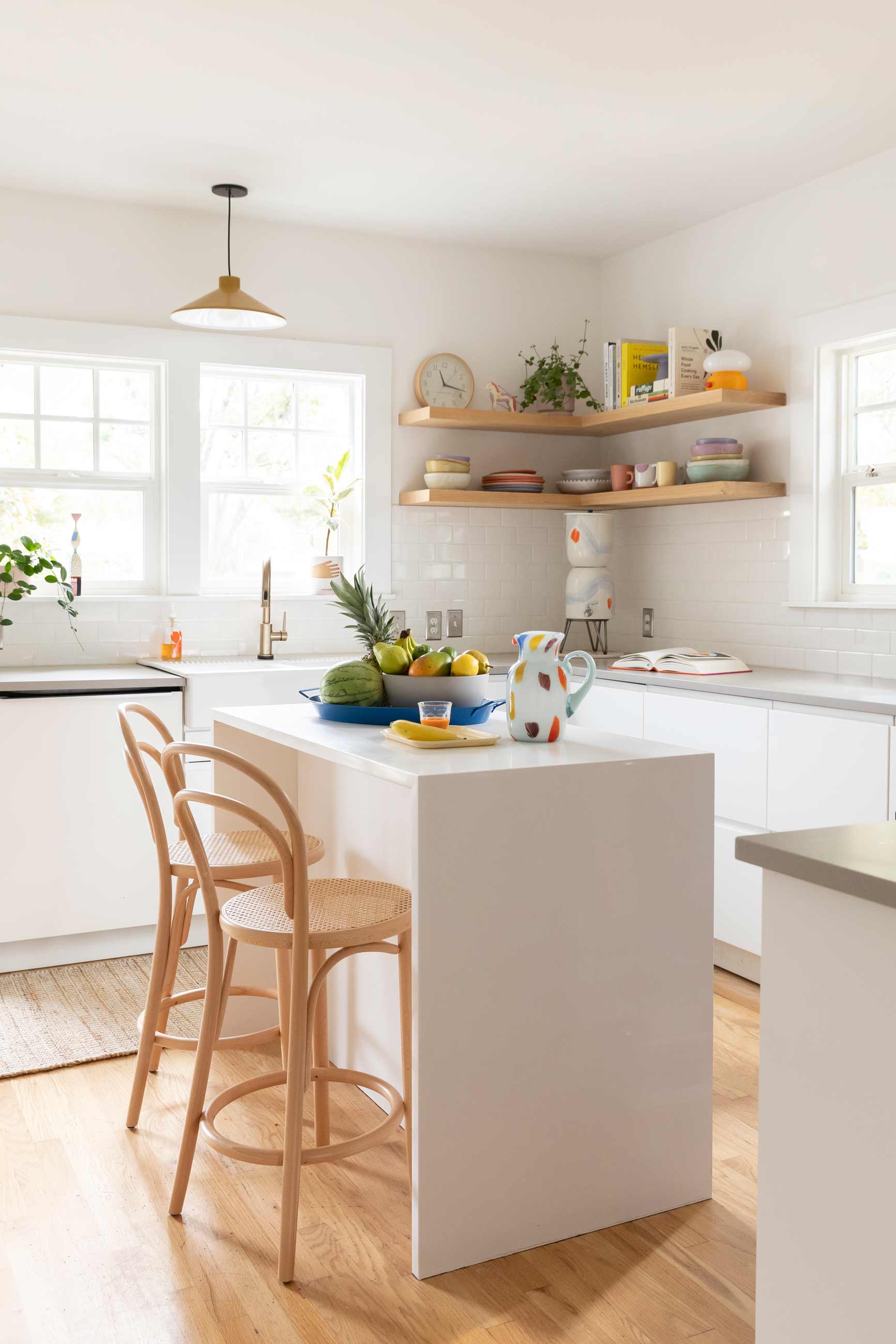 Bright kitchen with light wood floors and white cabinets.