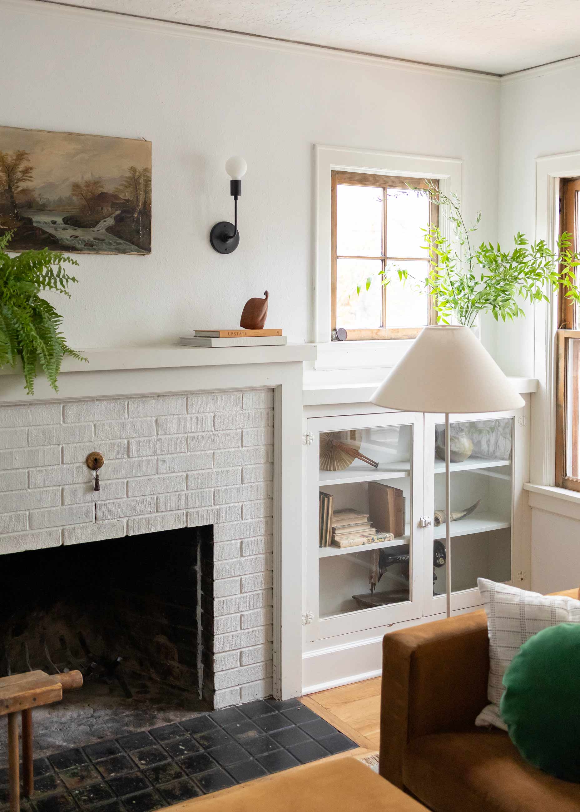 Bright and sunny living room with fireplace and plants. 