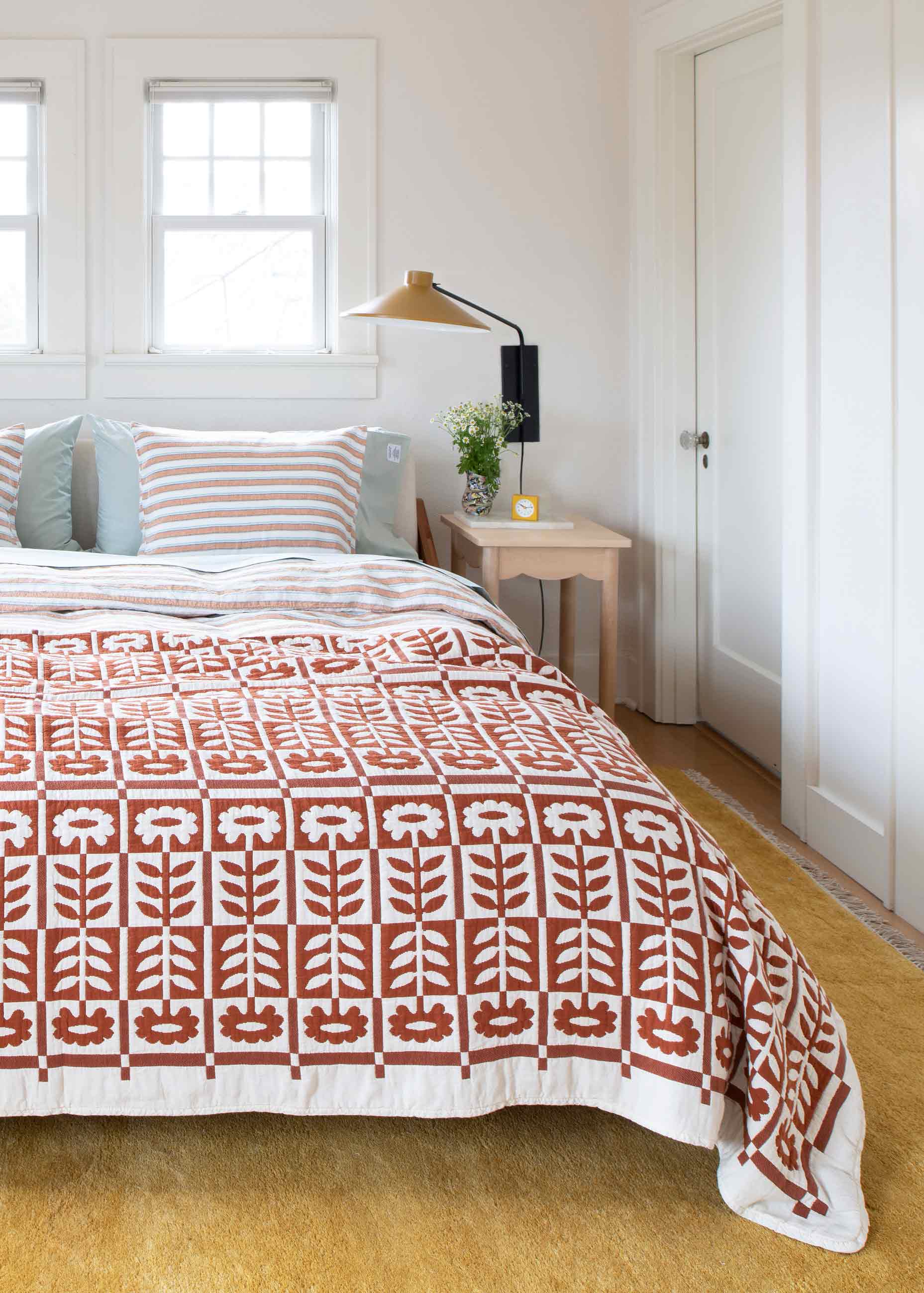 Bright and colorful bedroom with floral quilt on bed. 