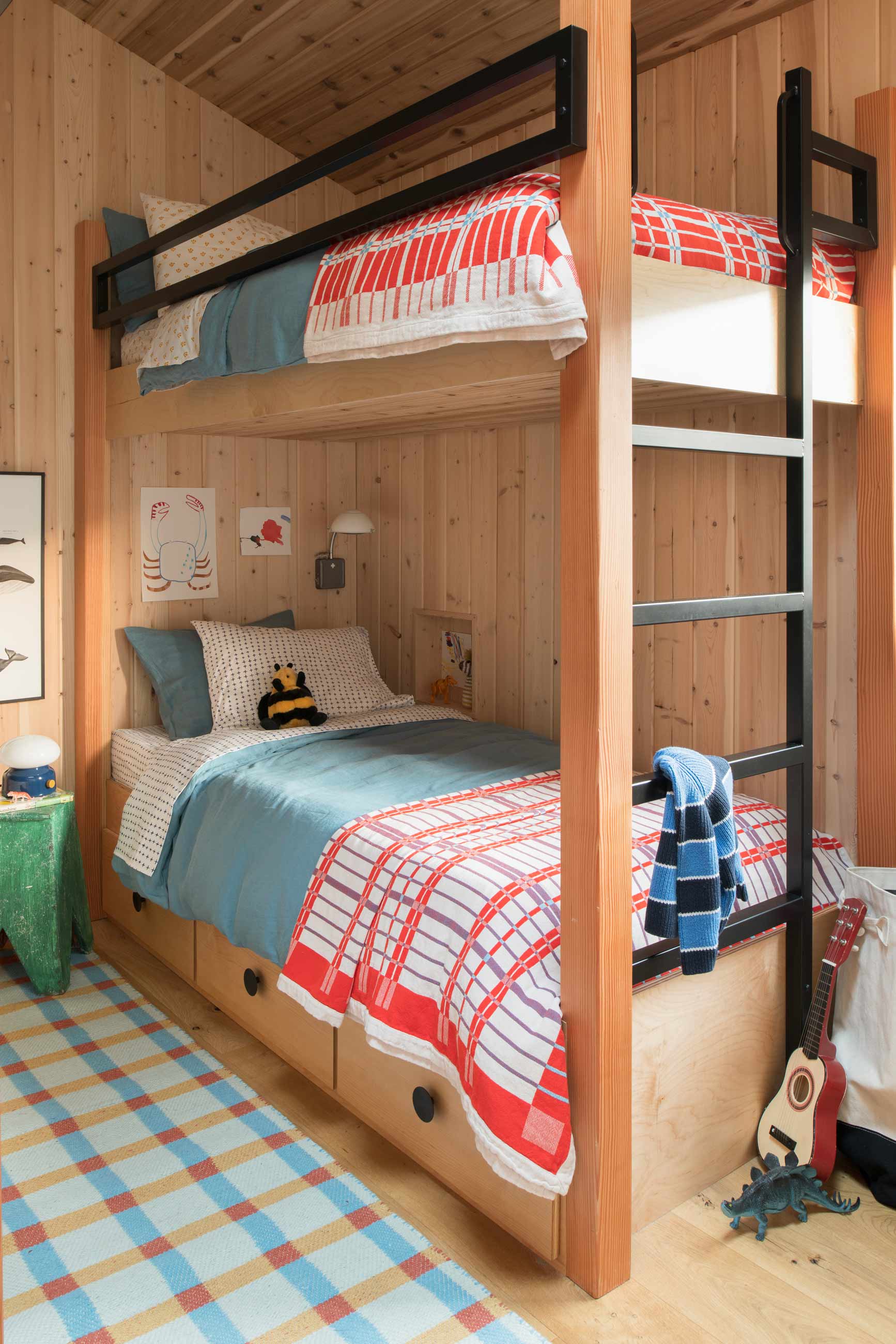 Cedar bunk beds made with blue and red contrasting bedding.