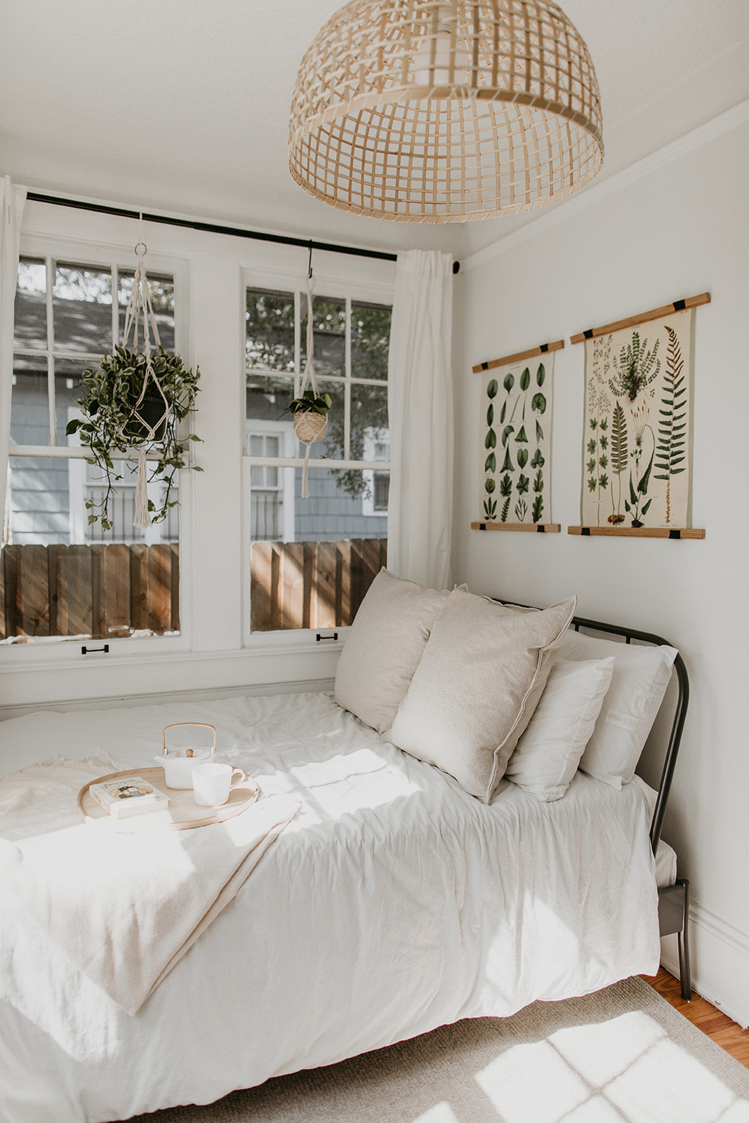 bed with a white sheet and a hanging light fixture