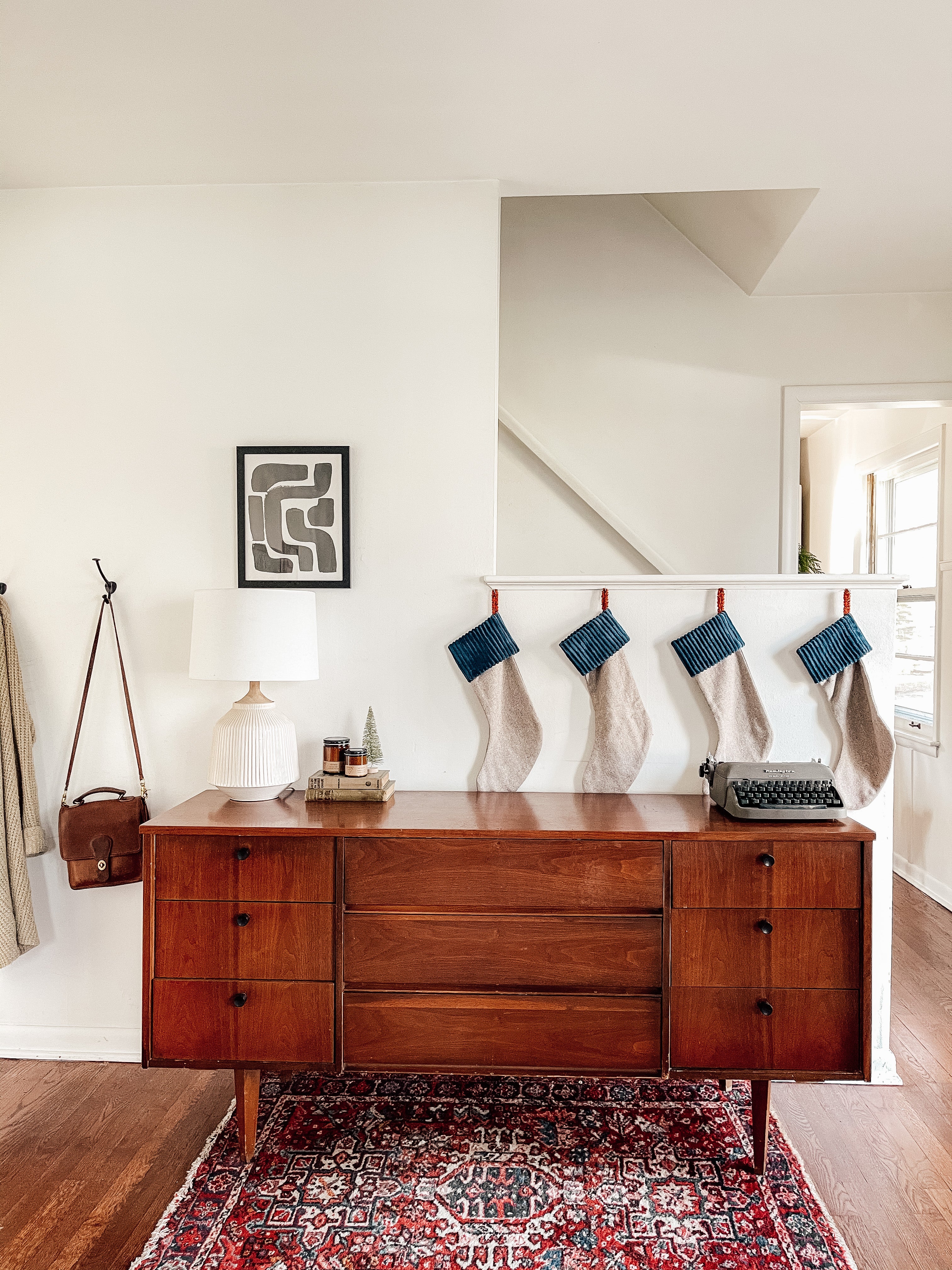 Identical stockings hanging above mid century modern credenza.