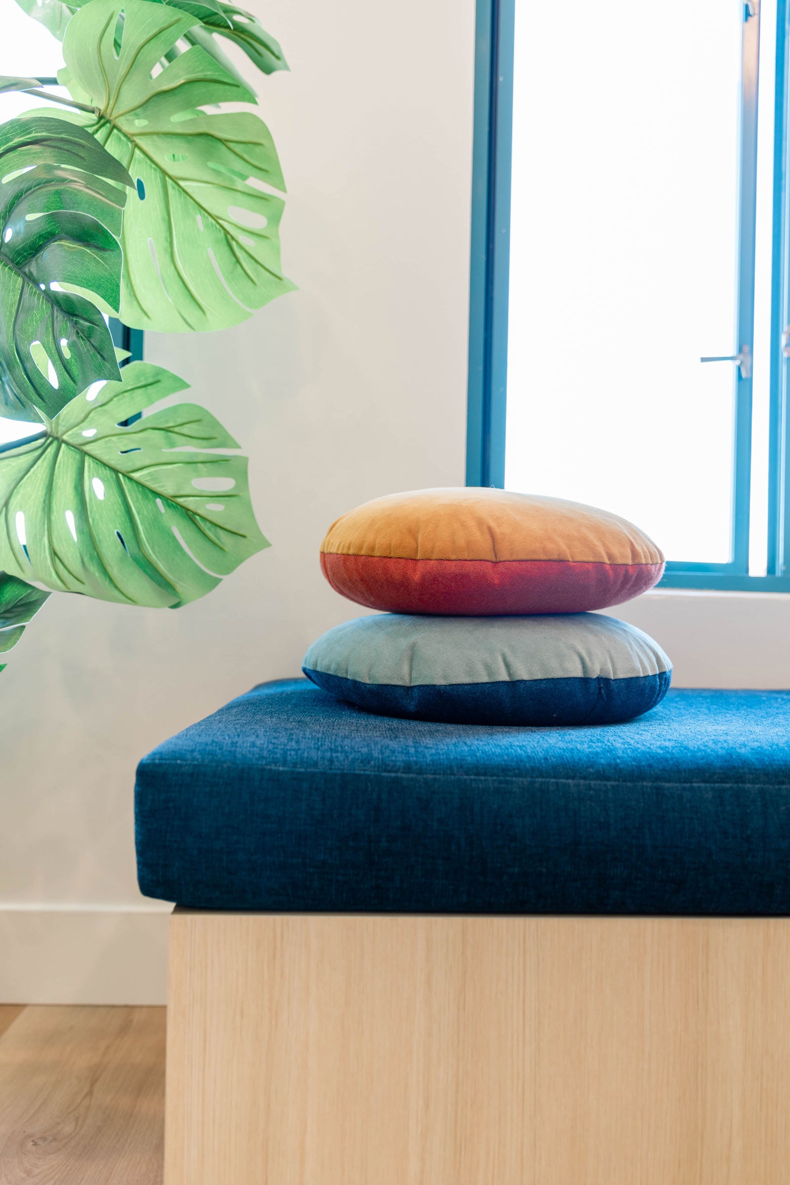 Circle pillows stacked on a cozy sitting bench.