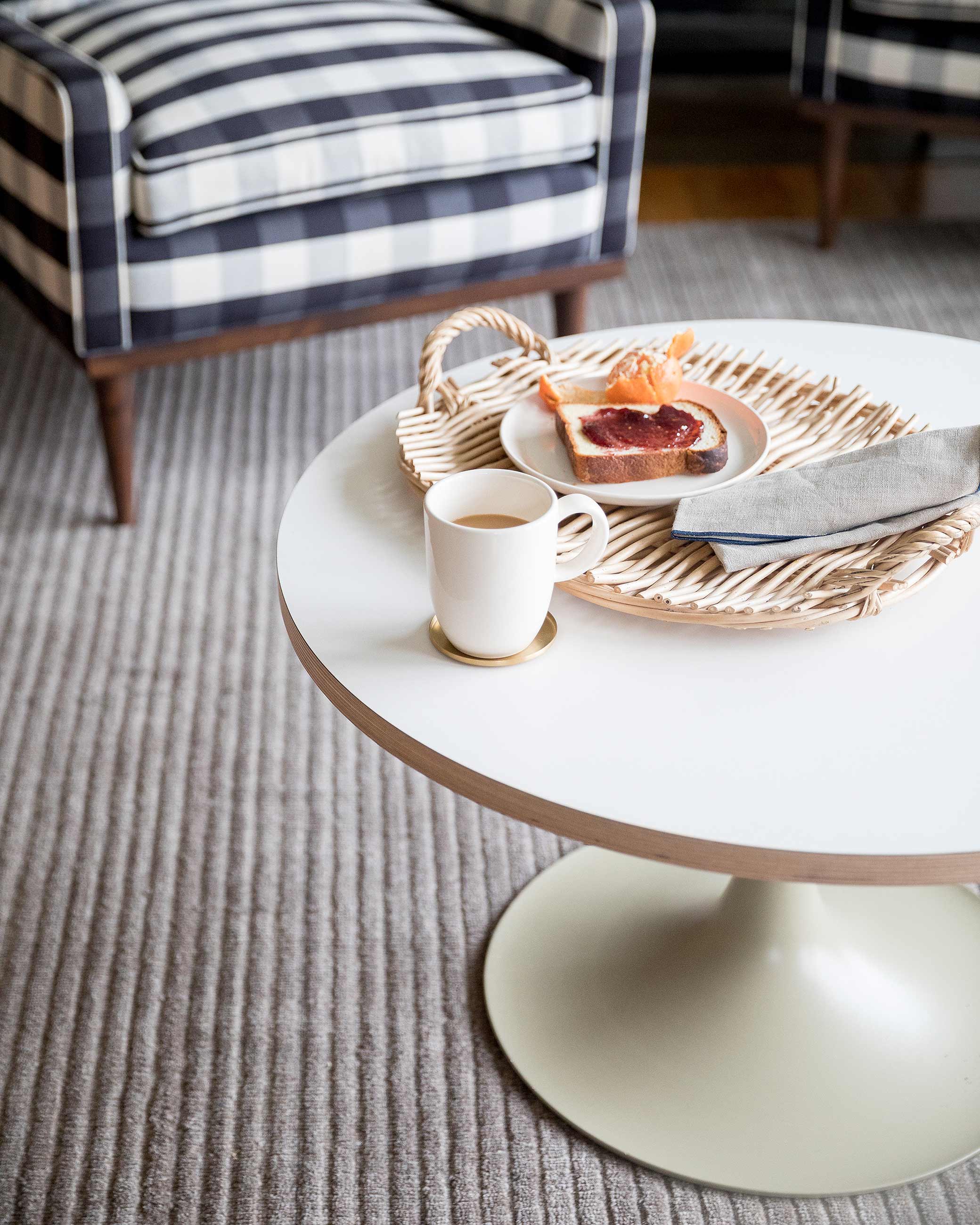 Closeup of coffee table with coffee mug, and plate with toast and jam.