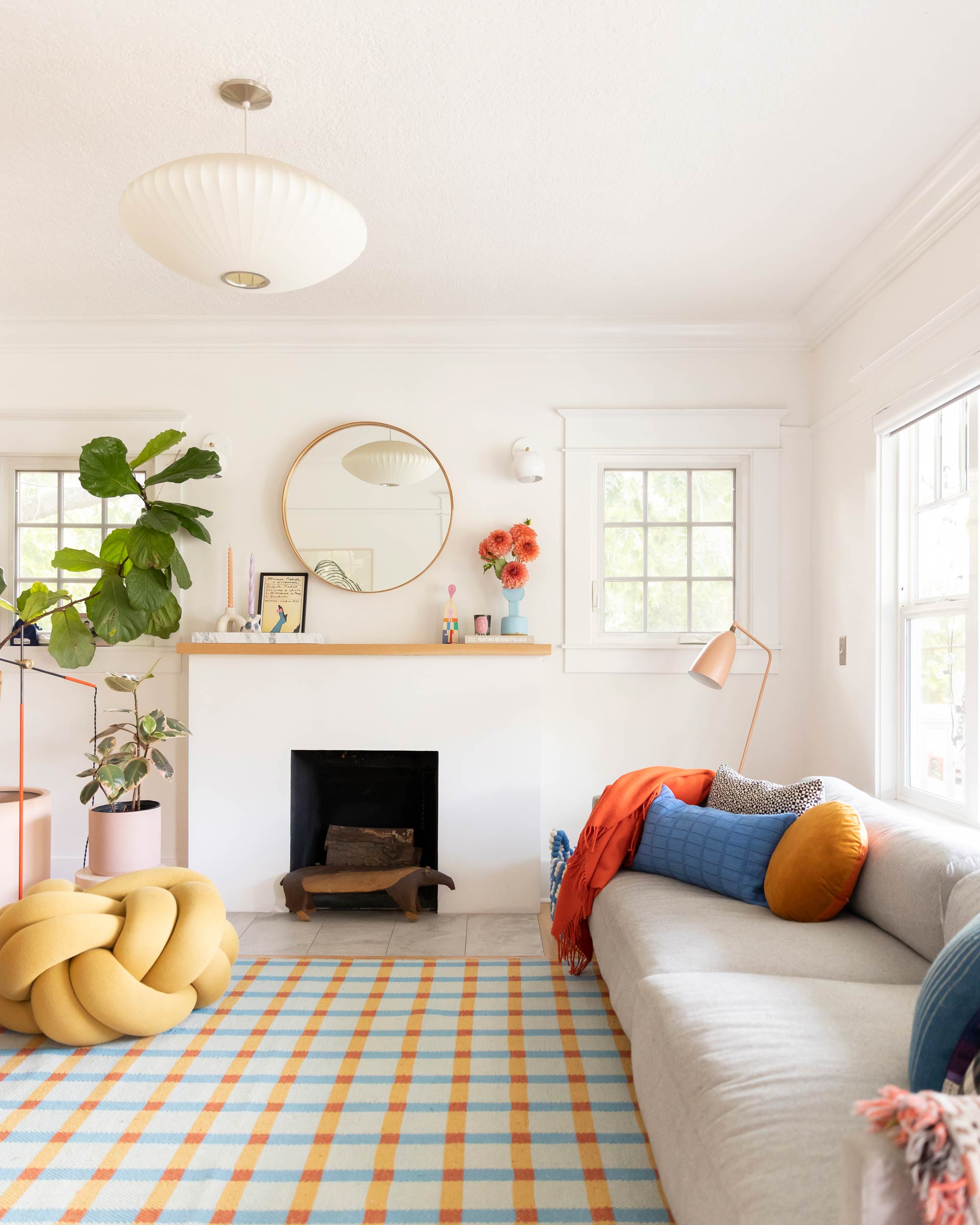 A bright living room with a colorful plaid wool rug. 