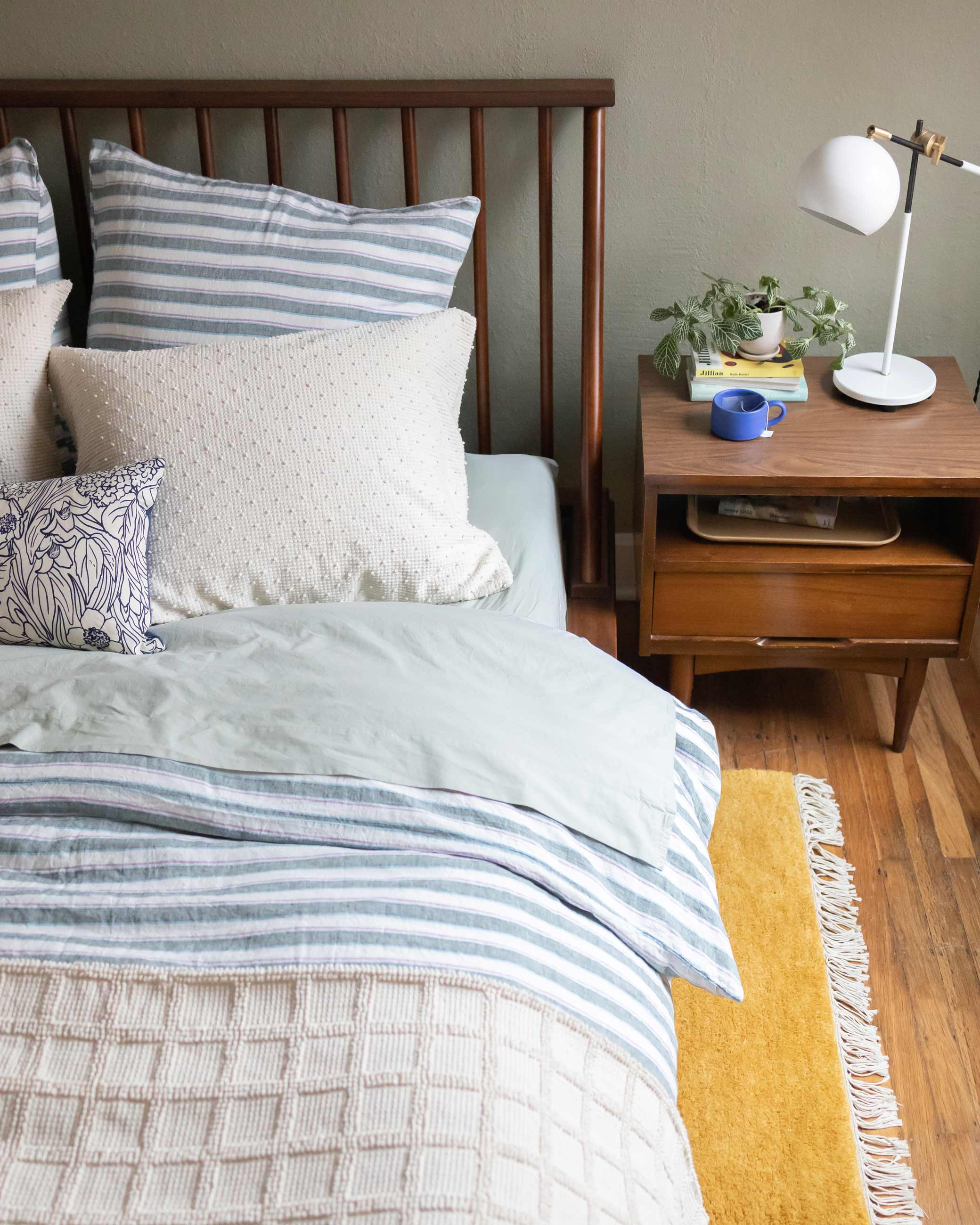 Bed with blue and white bedding in cozy bedroom.