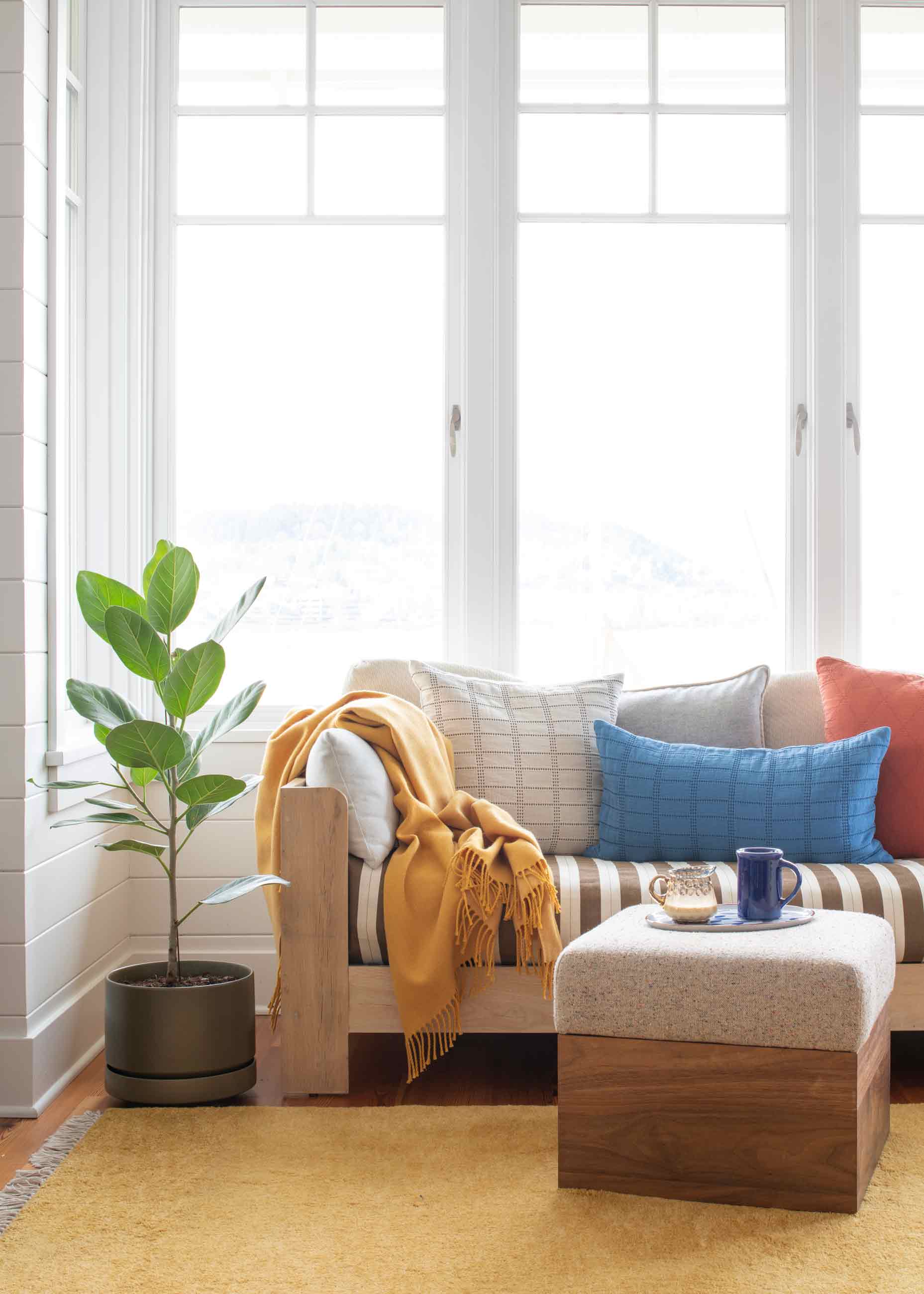 Couch in front of floor to ceiling windows. 