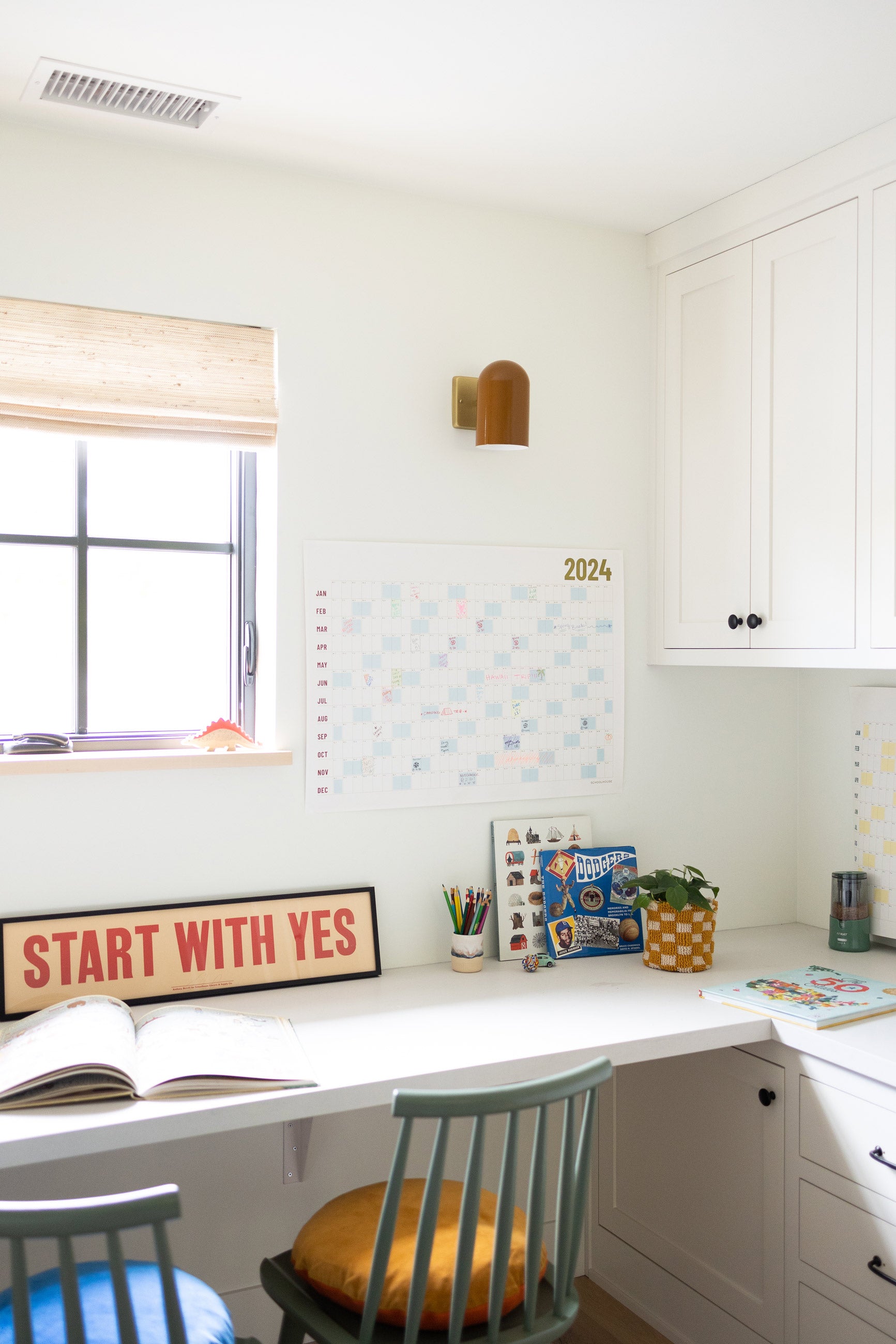 Desk nook with green chair and calendar. 