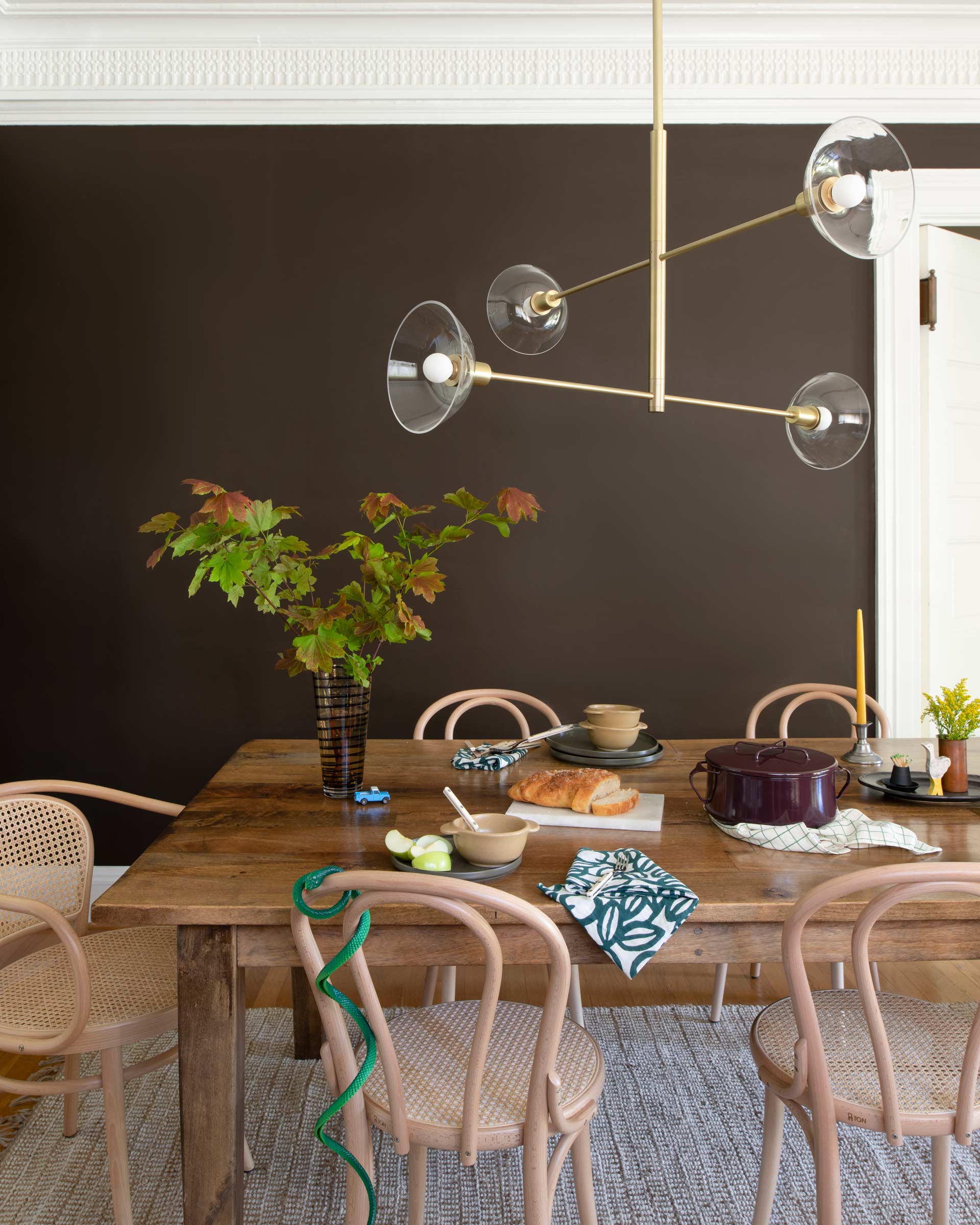 Dining room with a modern, brass chandelier above the table.