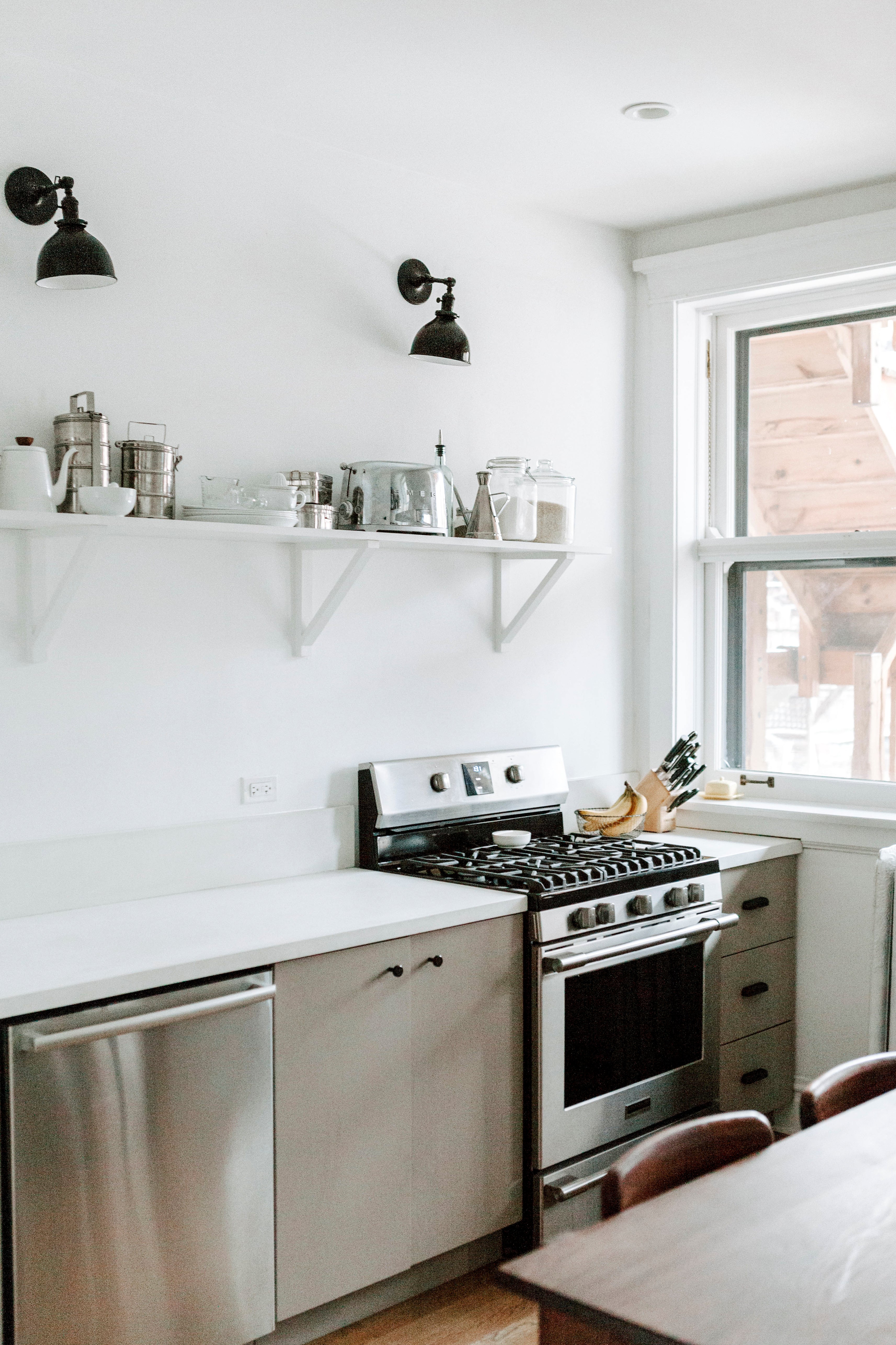 kitchen with a stove and cabinets and shelves on the wall