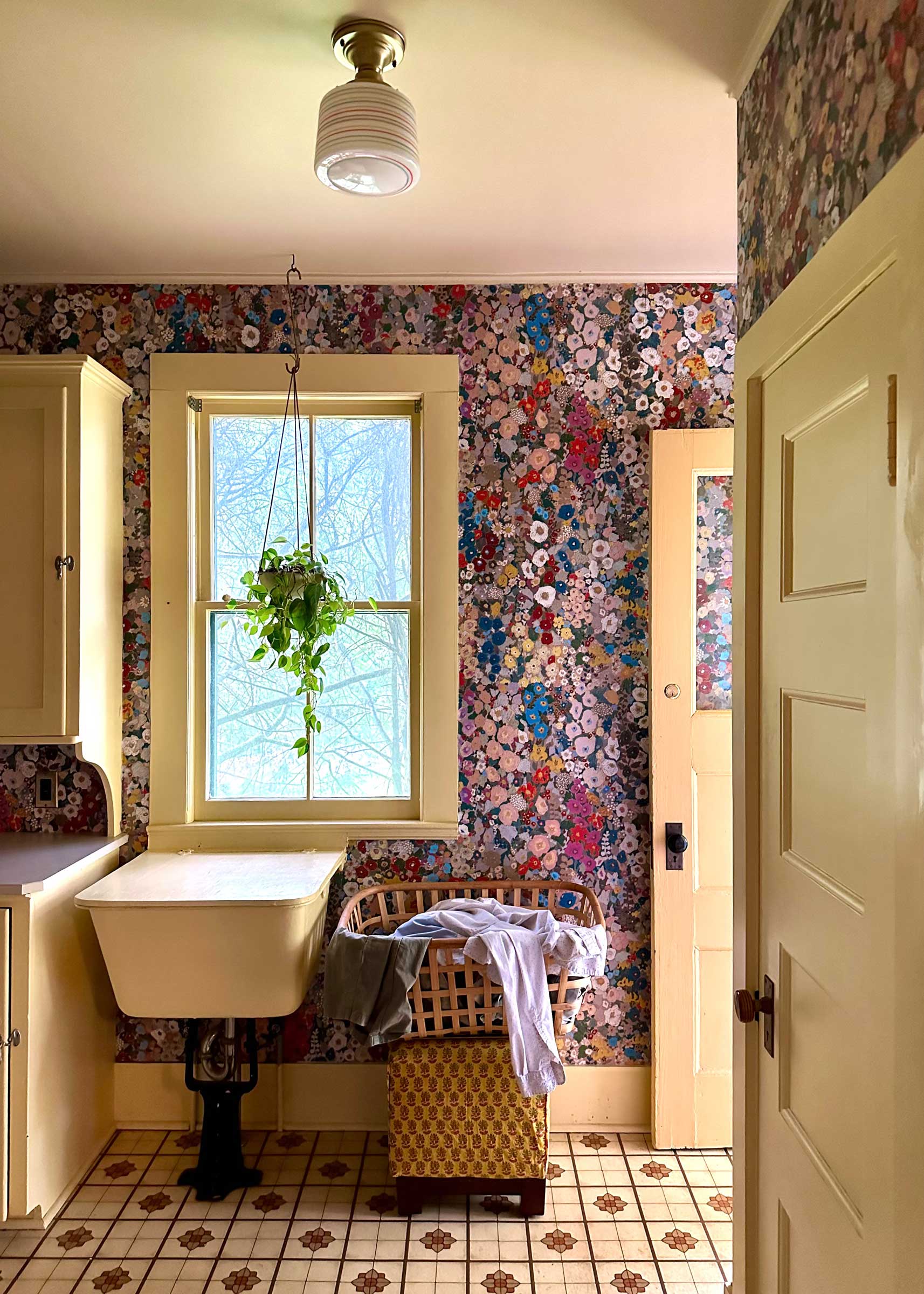 A laundry room with floral wallpaper.