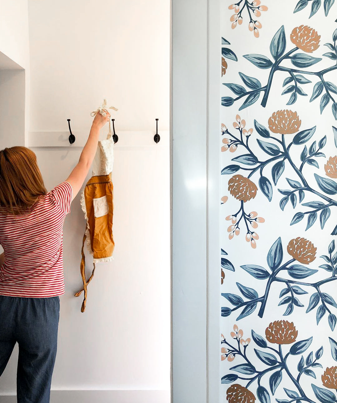 person hanging an item on a coat hook