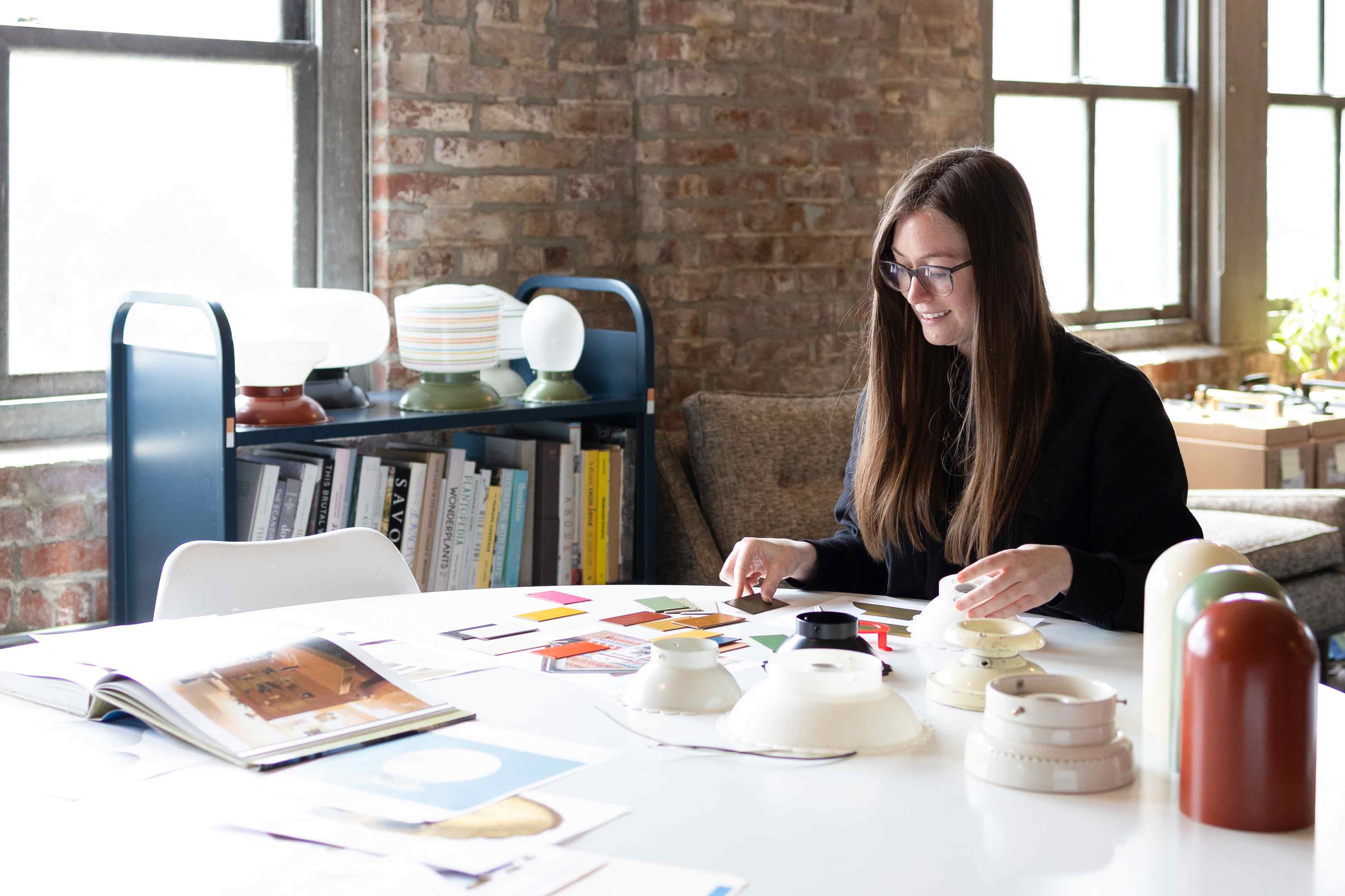 Person working at white table on design concept for Fran fixture. 