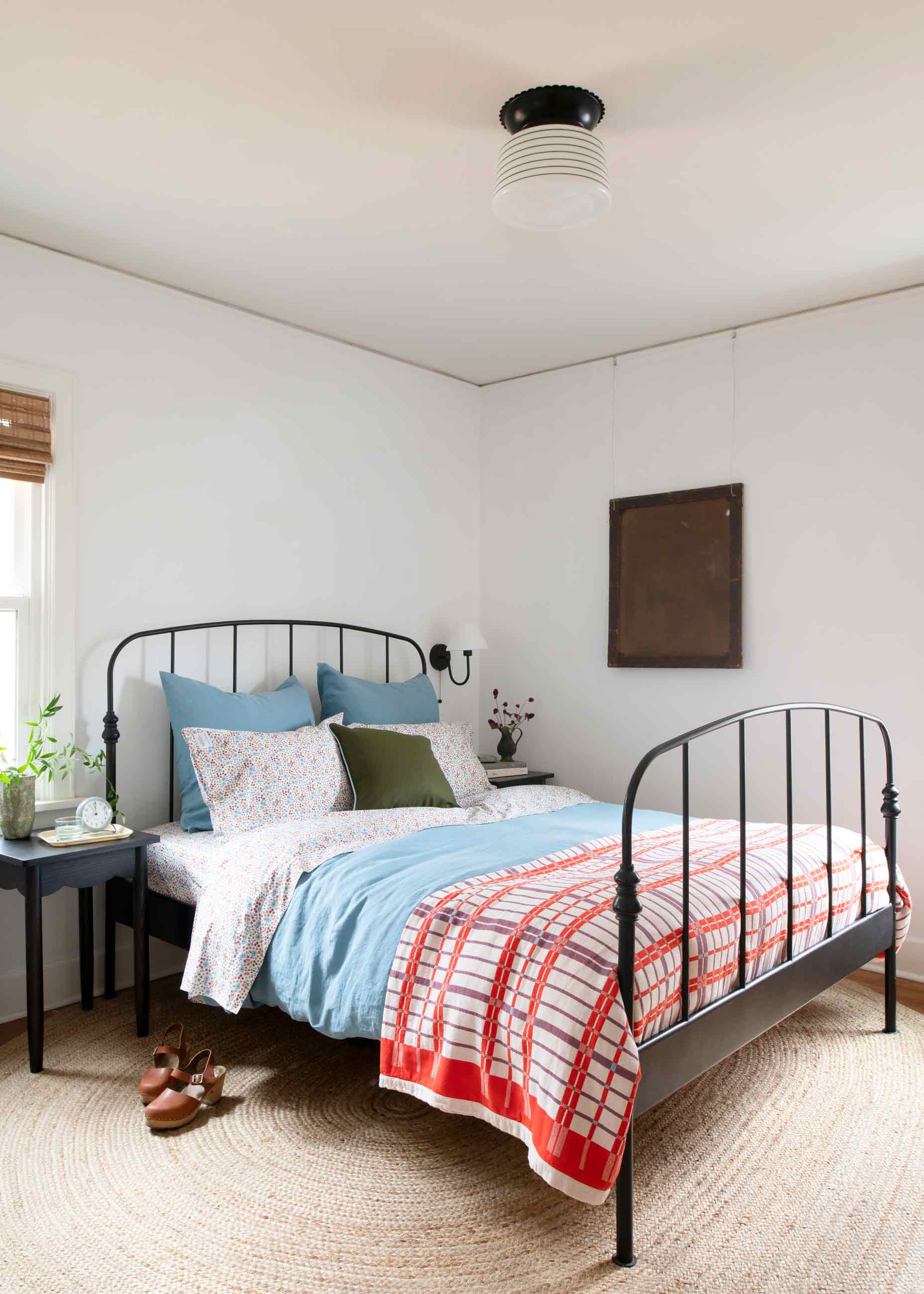 Scalloped light fixture above bed in bedroom.