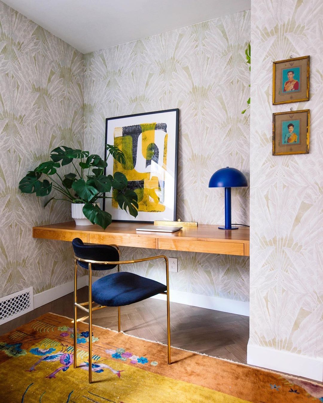 desk with a chair and a plant and blue table lamp on it