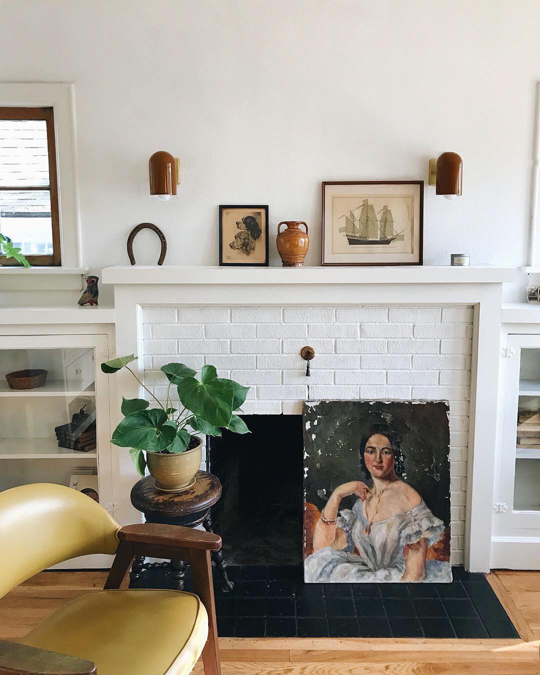 fireplace with a plant and artwork in the middle
