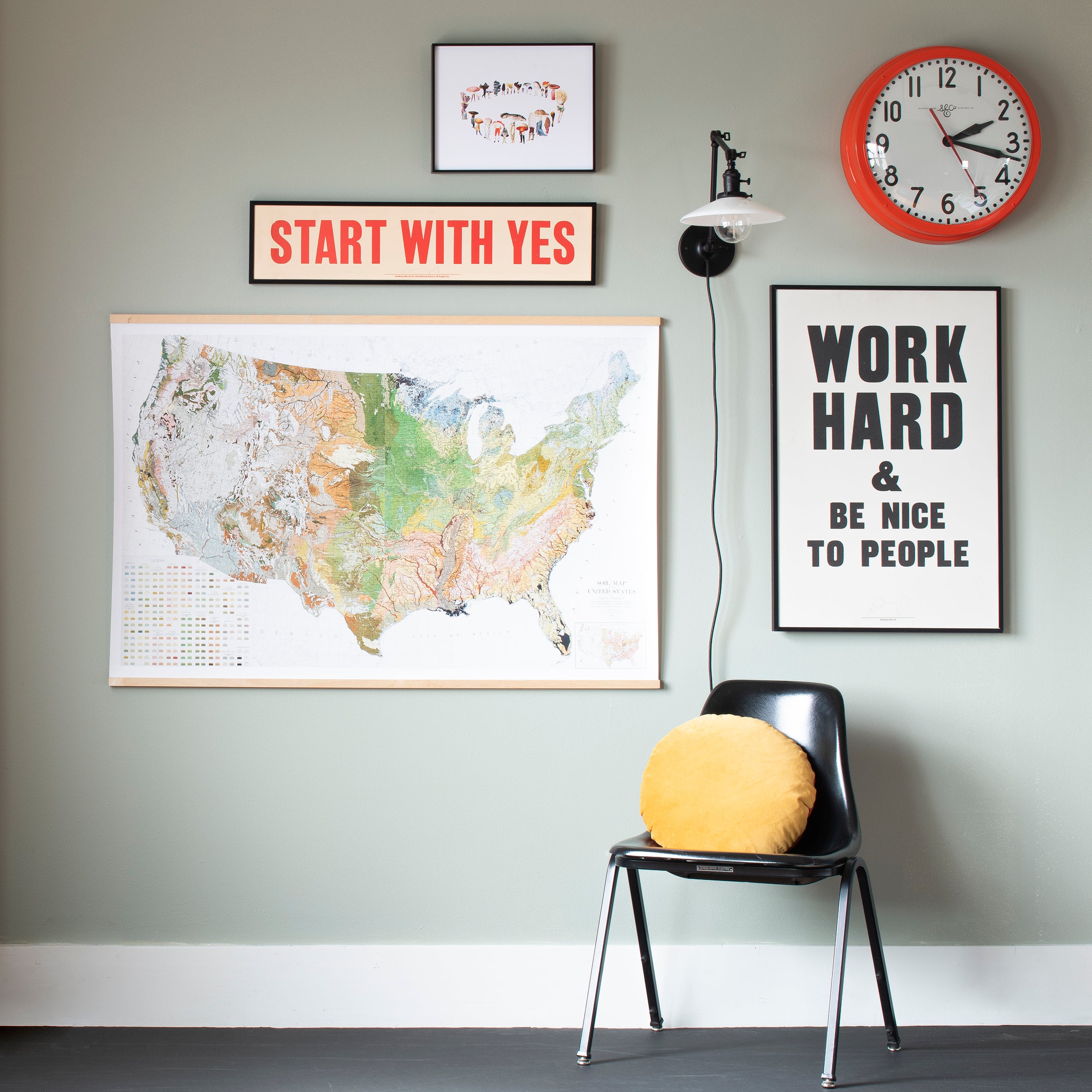 clock and a chair in a room with artwork