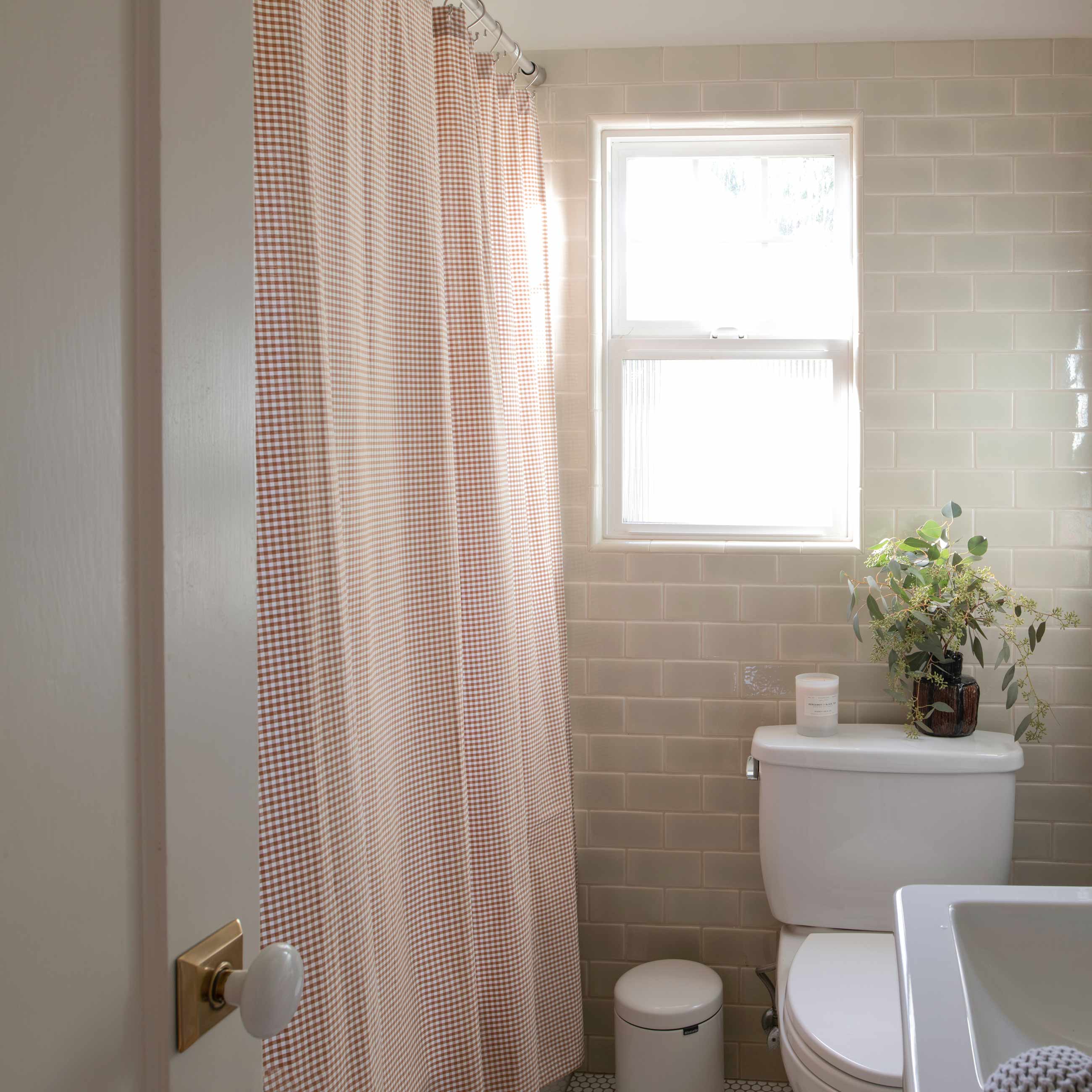 Gingham shower curtain in a neutral bathroom.