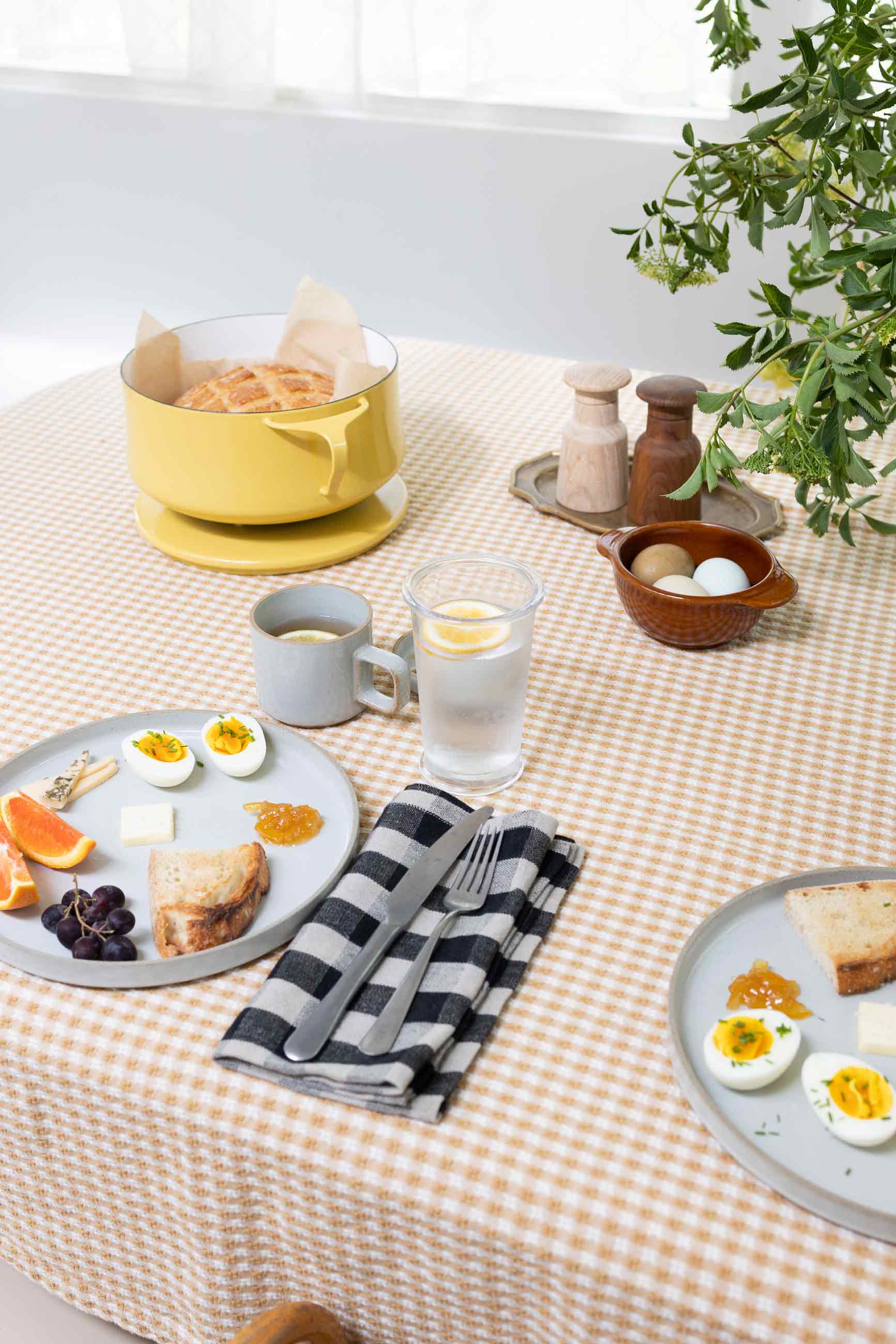 Gingham tablecloth on table with breakfast feast. 