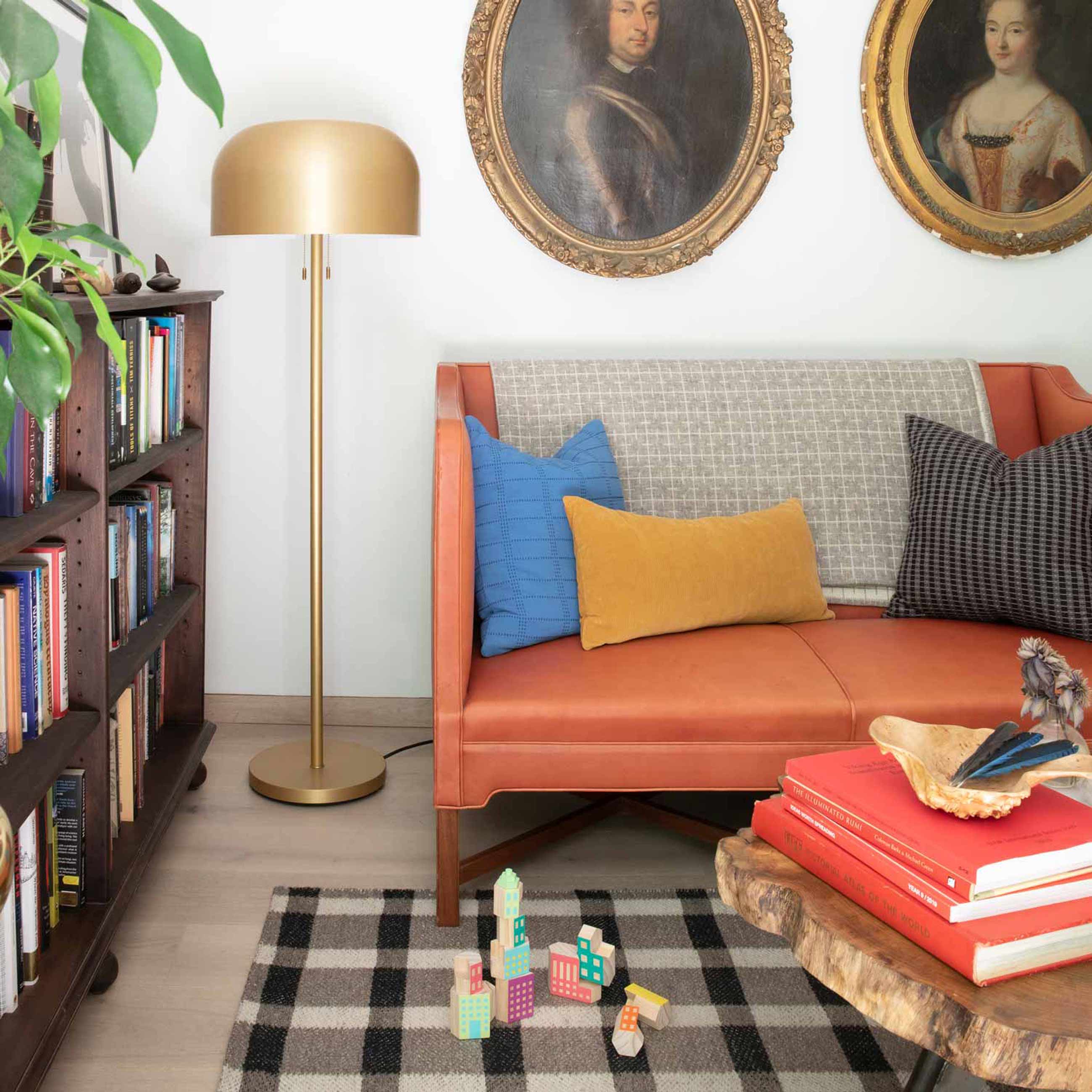 Gold floor lamp next to red couch in living room. 